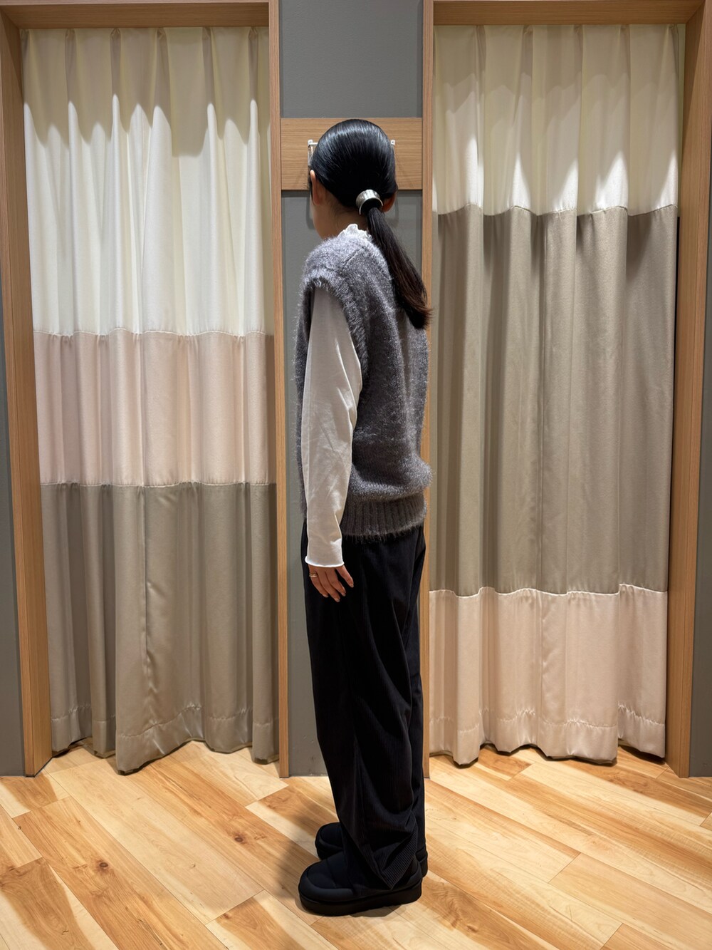 グレー系のパンツ、グレー系のトップス、ホワイト系のTシャツ/カットソーを着用したレディースの冬コーディネートの3枚目の写真