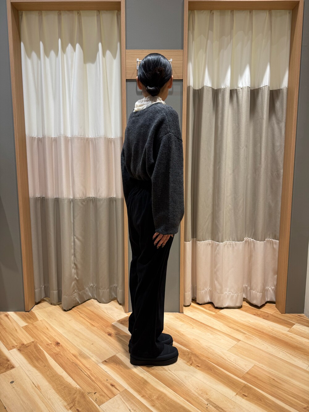 グレー系のニット/セーター、ホワイト系のTシャツ/カットソー、ブラック系のパンツを着用したレディースの冬コーディネートの4枚目の写真