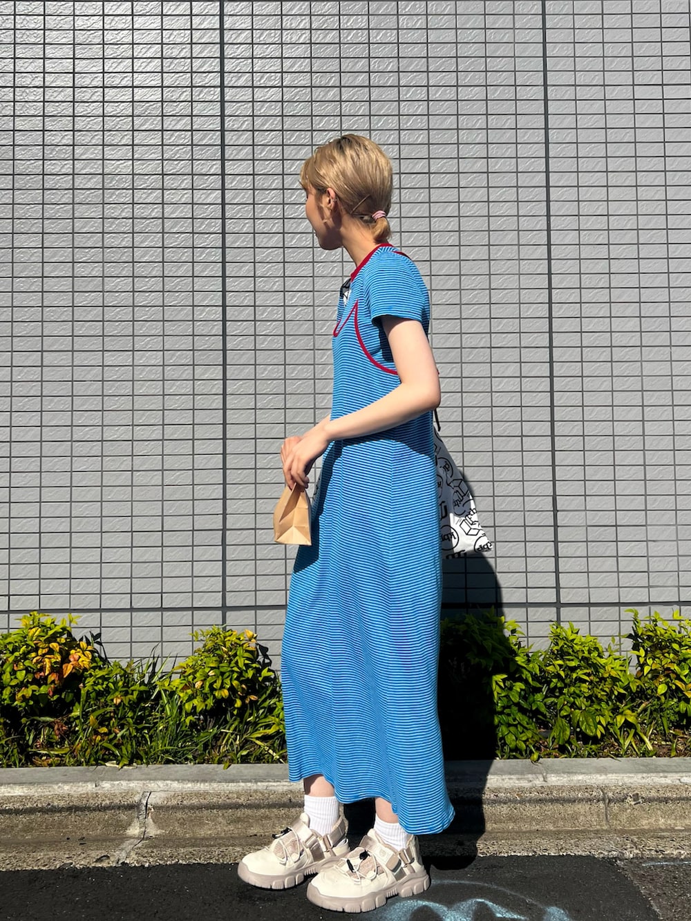 ベージュ系のサンダル、ブルー系のワンピースを着用したレディースの春コーディネートの3枚目の写真