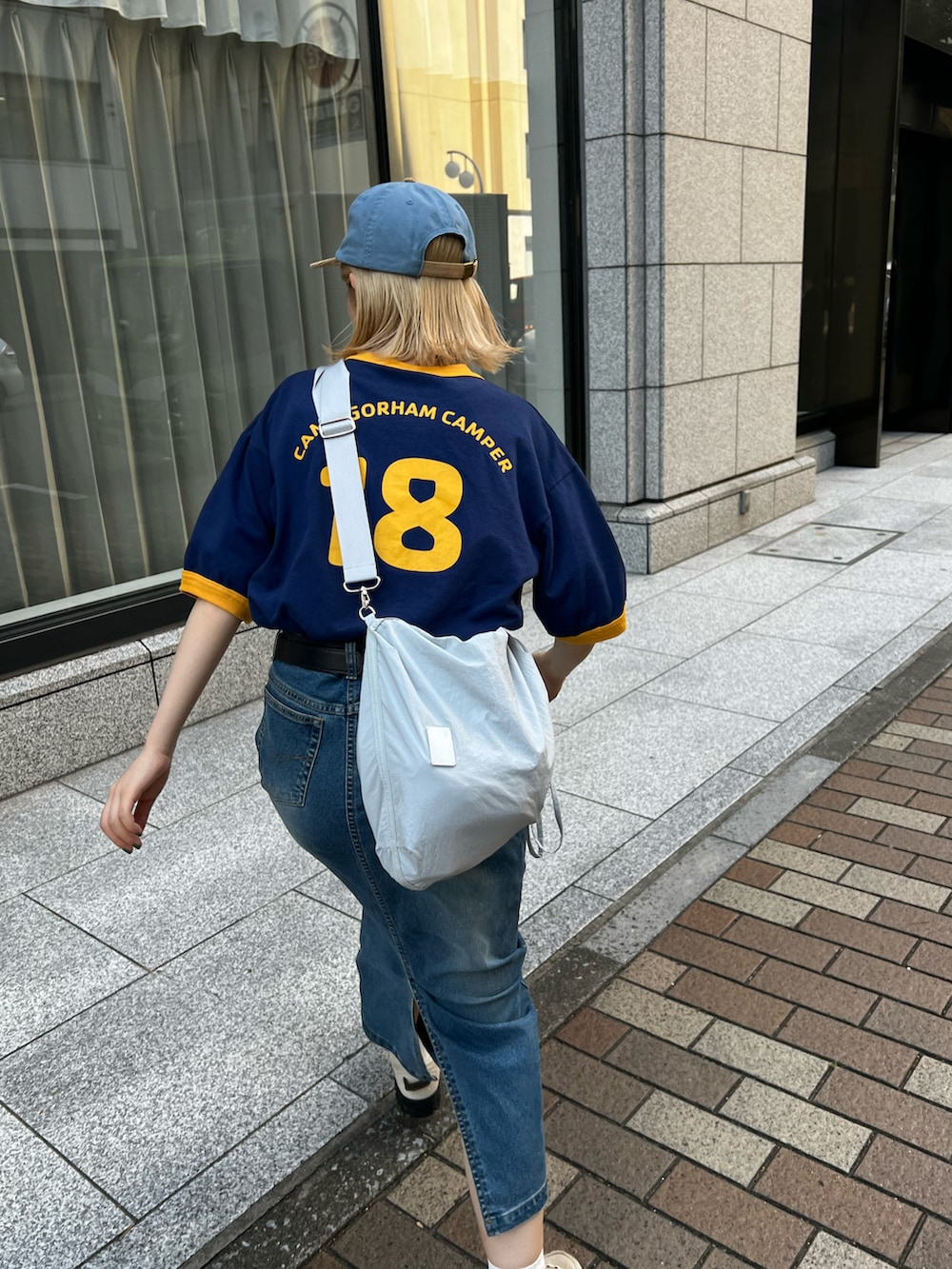 ベージュ系のスニーカー、ブルー系のデニムスカート、ブルー系のTシャツ/カットソーを着用したレディースの夏コーディネートの3枚目の写真