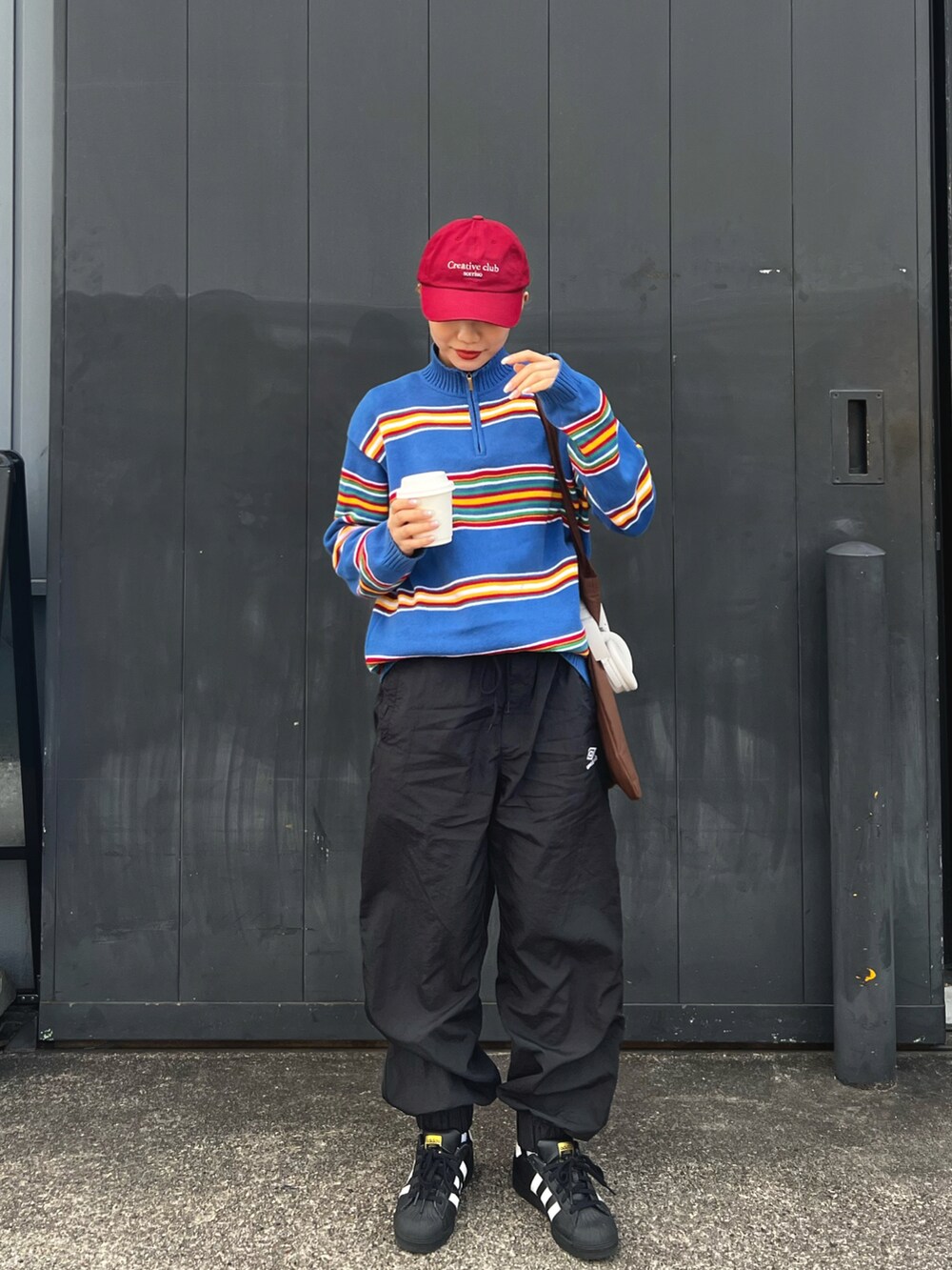 ブラック系のその他パンツ、ホワイト系のスニーカー、ブラウン系のトートバッグを着用したレディースの冬コーディネートの3枚目の写真