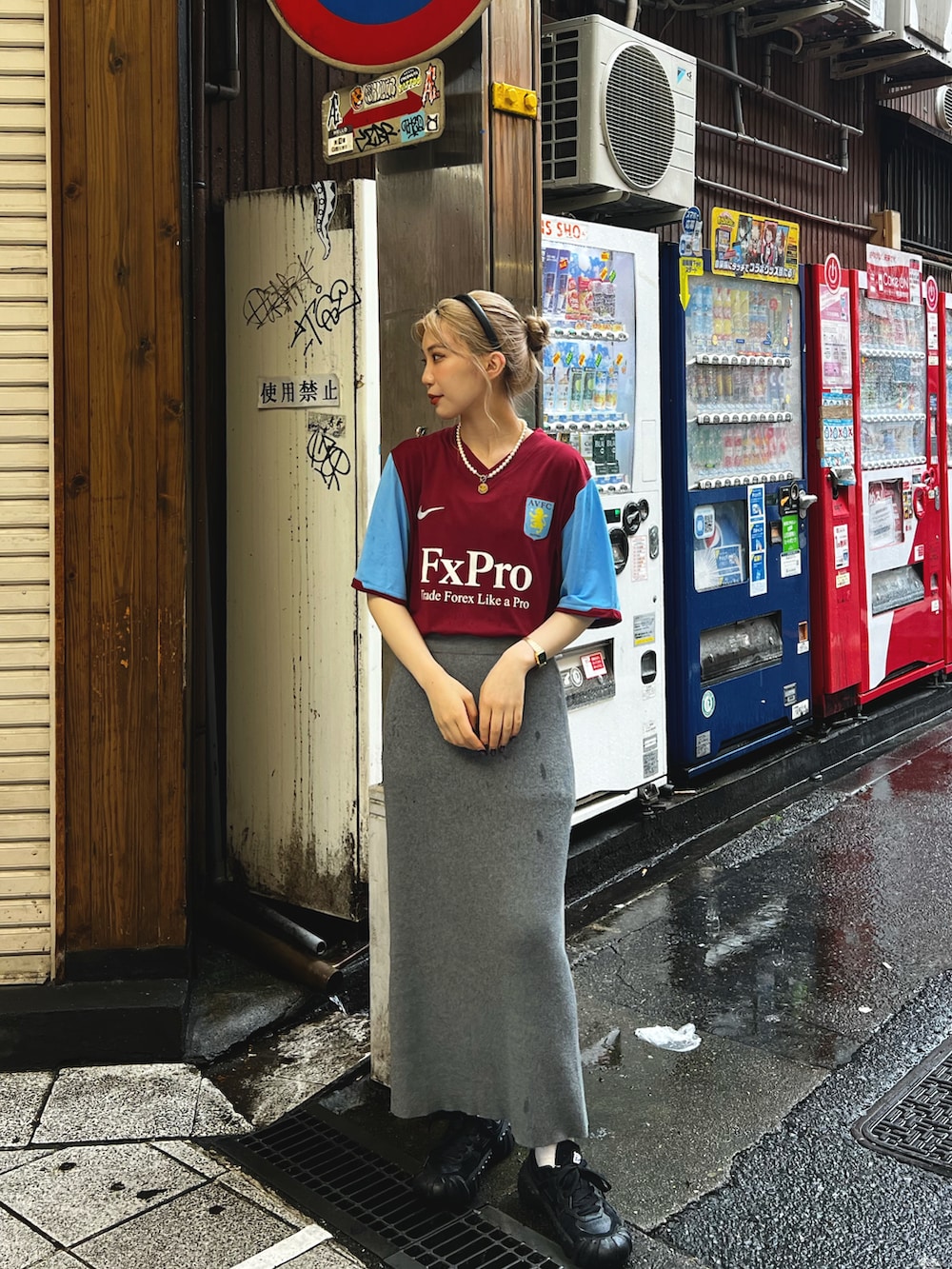 ピンク系のトップス、グレー系のスカート、ブラック系のスニーカーを着用したレディースの夏コーディネートの2枚目の写真