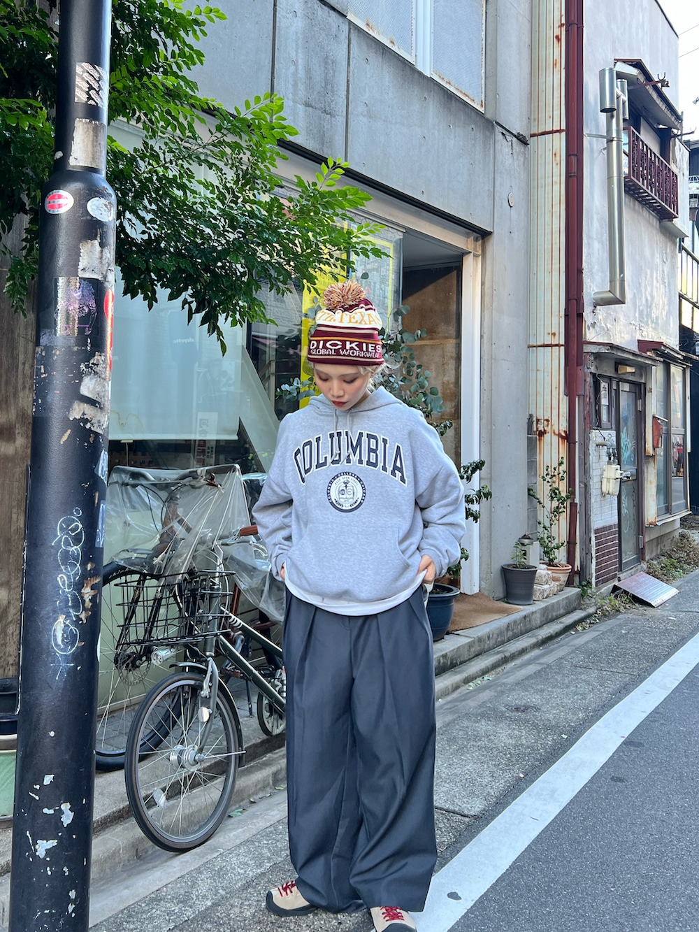 グレー系のスラックス、ベージュ系のスニーカーを着用したレディースの秋コーディネートの2枚目の写真