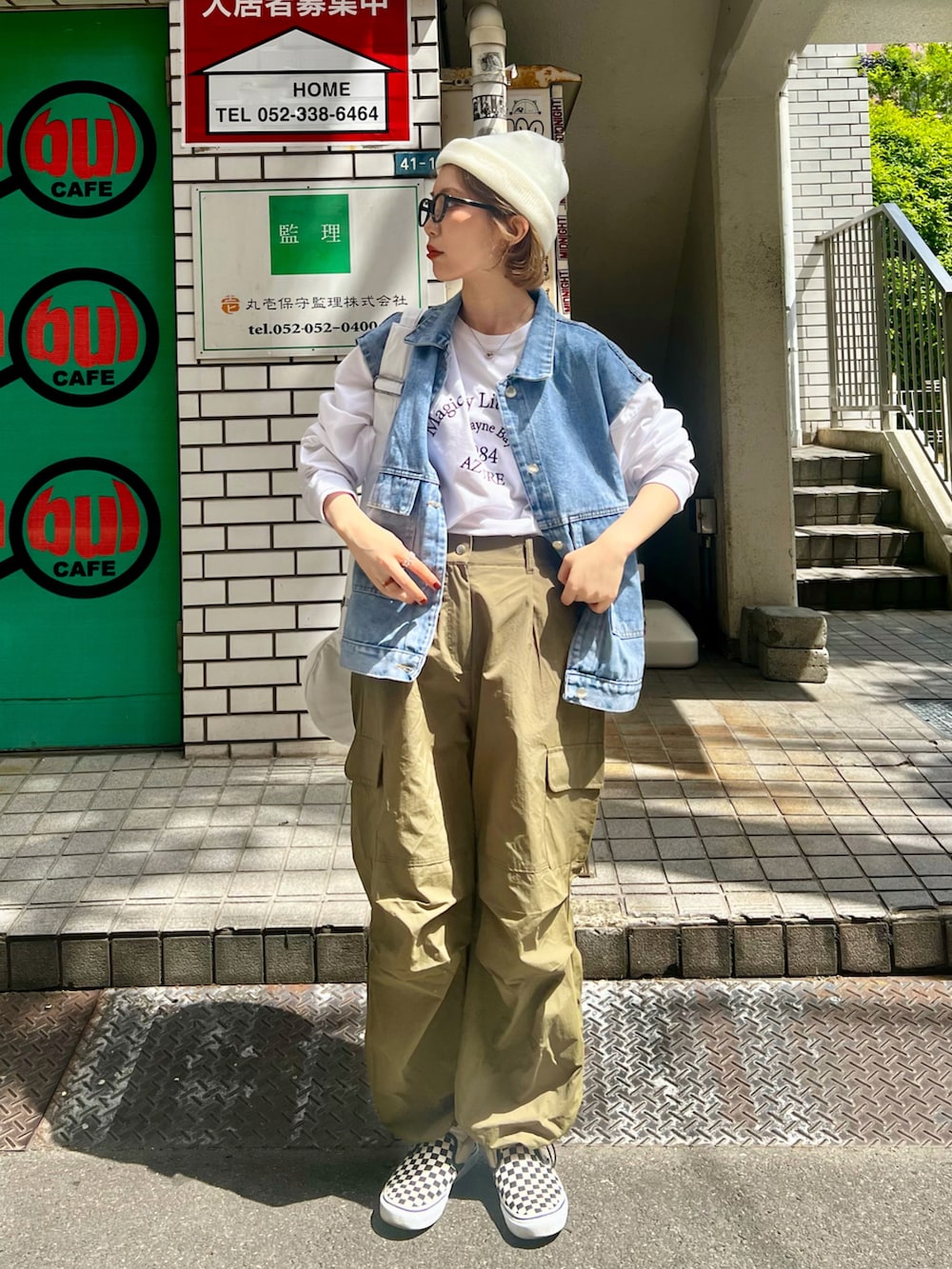 ホワイト系のカーゴパンツ、ホワイト系のスリッポン、ブルー系のベストを着用したレディースの春コーディネートの2枚目の写真