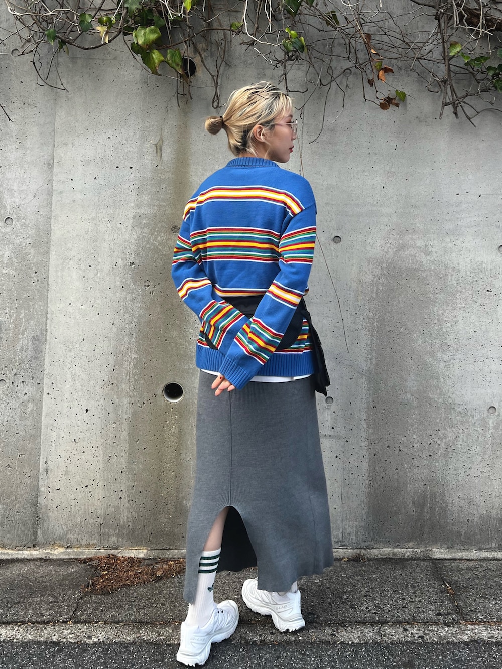 ブルー系のニット/セーター、グレー系のスカート、ブラック系のボディバッグ/ウエストポーチを着用したレディースの冬コーディネートの3枚目の写真