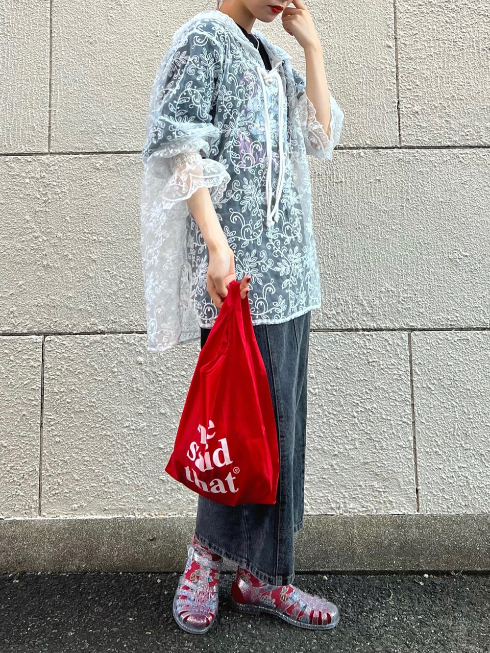 ホワイト系のトップス、レッド系のエコバッグ/サブバッグ、ブラック系のデニムスカートを着用したレディースの秋コーディネートの3枚目の写真