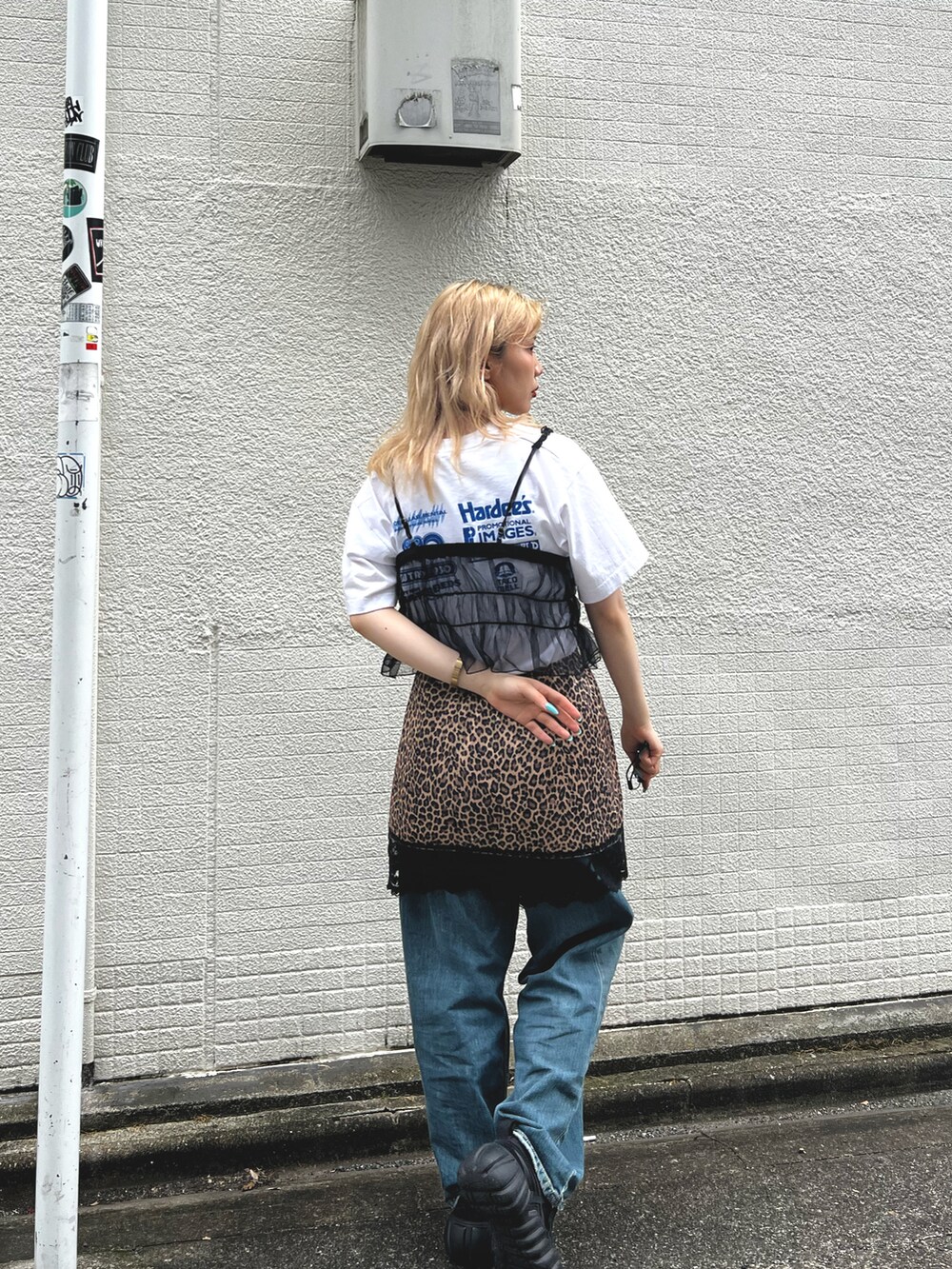 ブルー系のデニムパンツ、ブラック系のキャミソール、ブラック系のスニーカーを着用したレディースの夏コーディネートの2枚目の写真