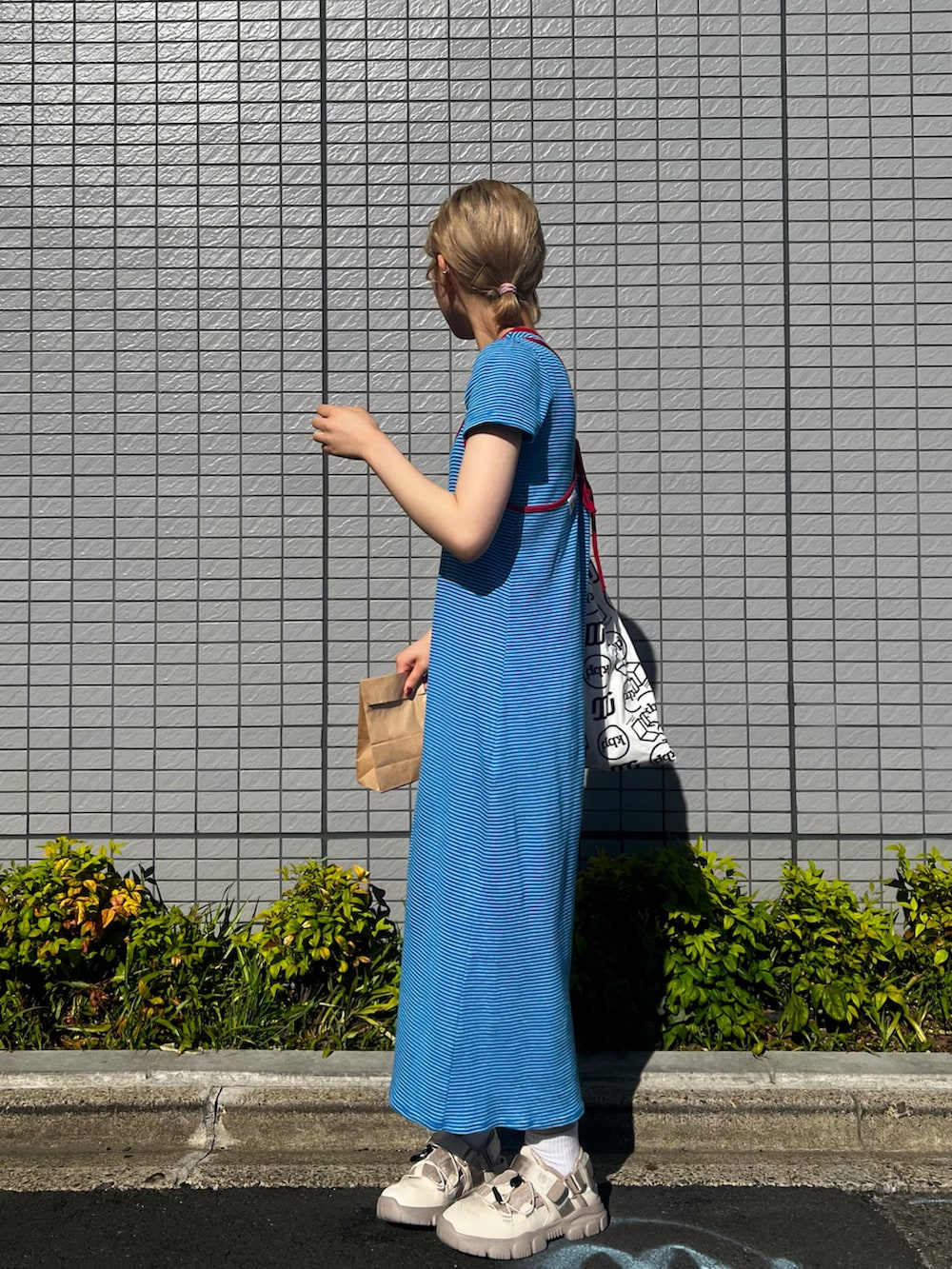 ベージュ系のサンダル、ブルー系のワンピースを着用したレディースの春コーディネートの2枚目の写真