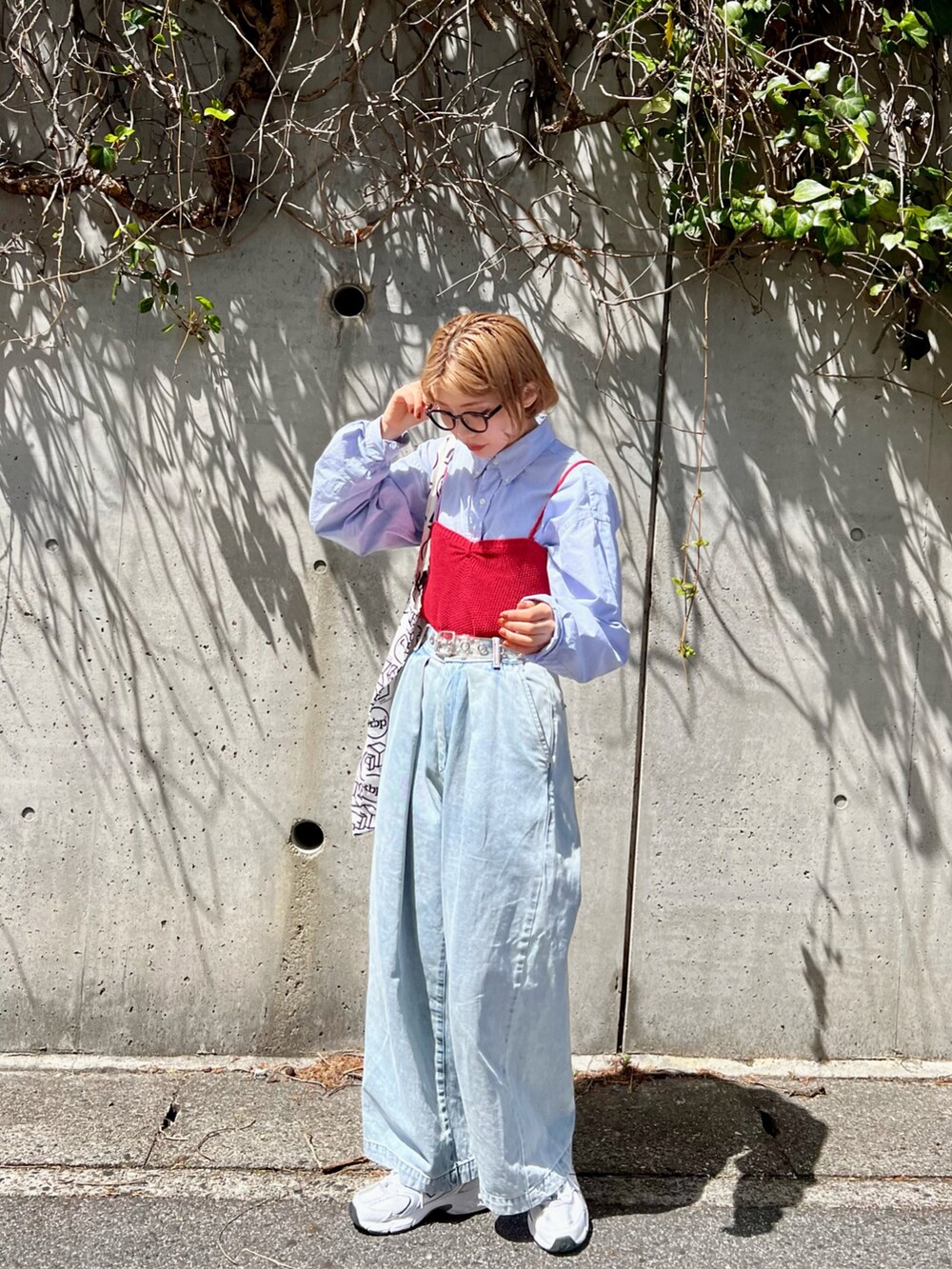 ブルー系のスラックス、ブルー系のシャツ/ブラウス、レッド系のチューブトップを着用したレディースの春コーディネートの3枚目の写真