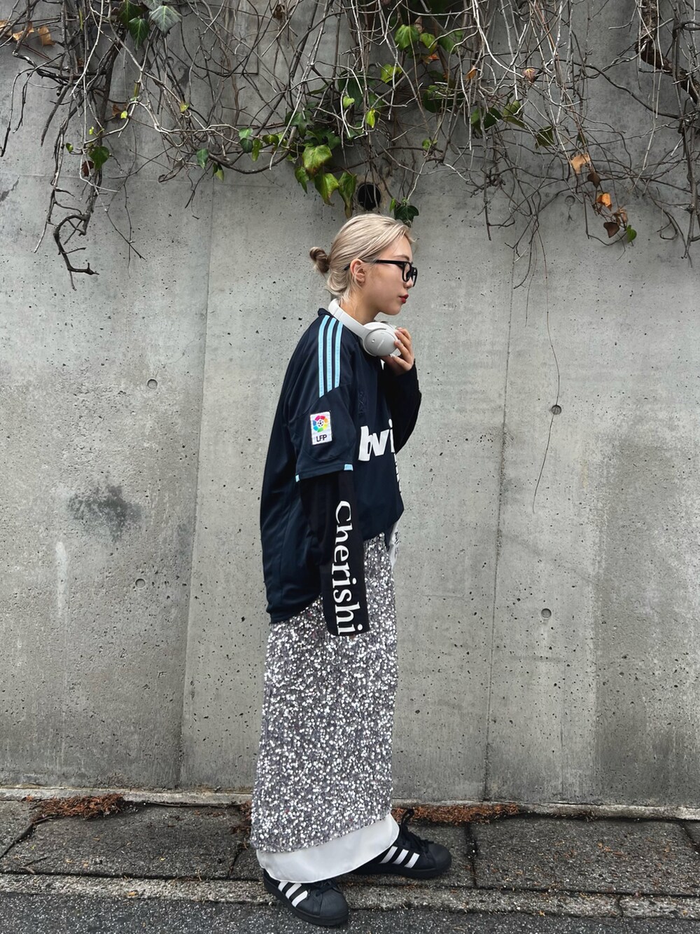 ホワイト系のスニーカー、シルバー系のスカート、ブルー系のトップスを着用したレディースの冬コーディネートの4枚目の写真