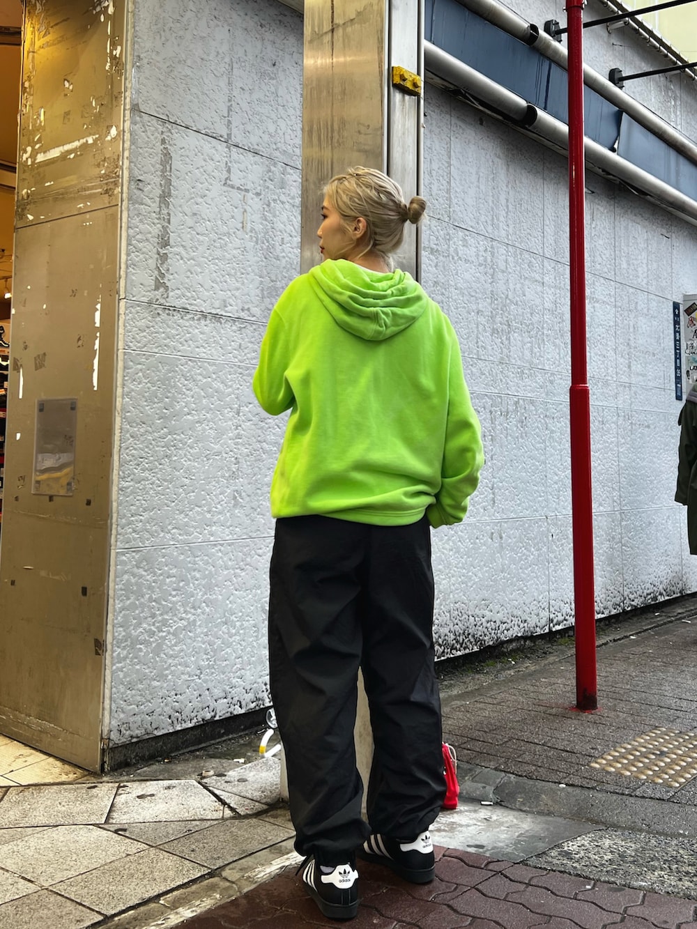 グリーン系のパーカー、ブラック系のその他パンツ、ホワイト系のスニーカーを着用したレディースの冬コーディネートの3枚目の写真