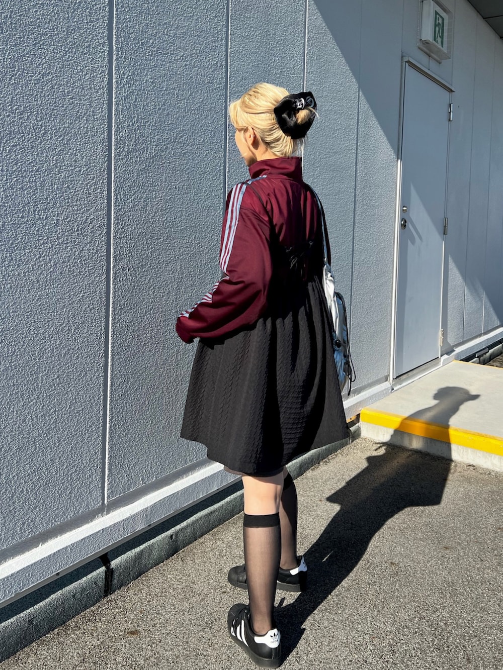 ホワイト系のスニーカー、レッド系のジャージ、シルバー系のショルダーバッグを着用したレディースの秋コーディネートの3枚目の写真