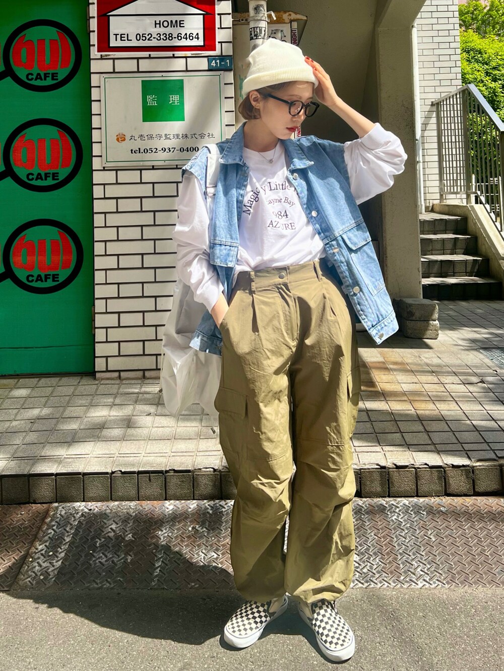 ホワイト系のカーゴパンツ、ホワイト系のスリッポン、ブルー系のベストを着用したレディースの春コーディネートの3枚目の写真