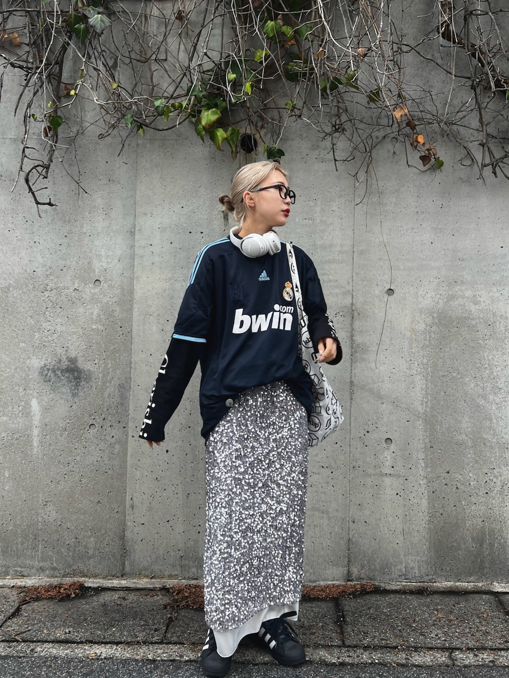 ホワイト系のスニーカー、シルバー系のスカート、ブルー系のトップスを着用したレディースの冬コーディネートの2枚目の写真