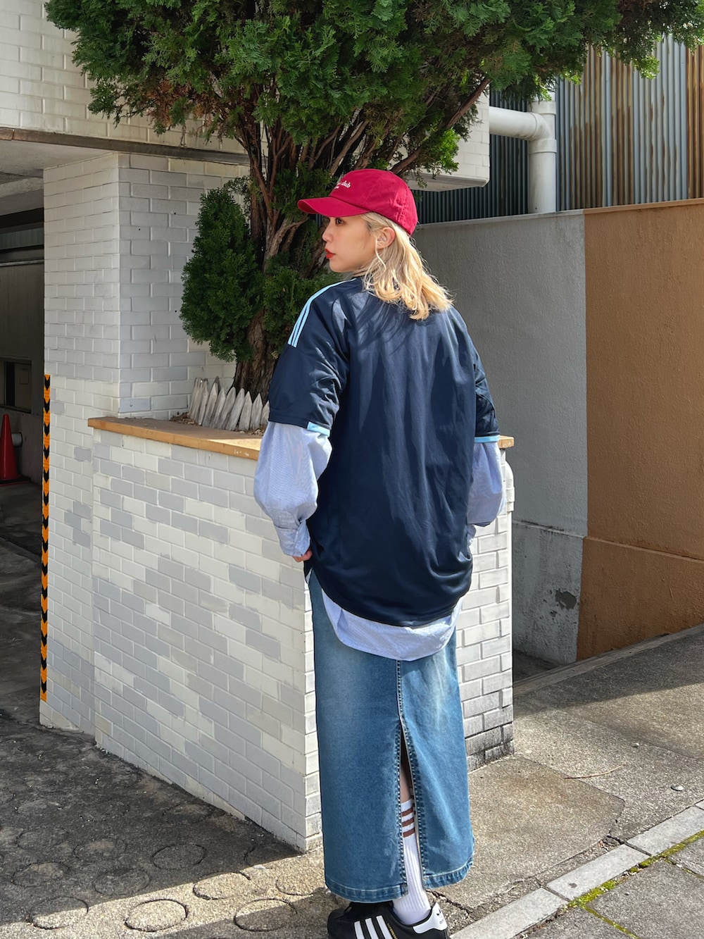 ブルー系のデニムスカート、ホワイト系のスニーカー、ブルー系のトップスを着用したレディースの冬コーディネートの3枚目の写真