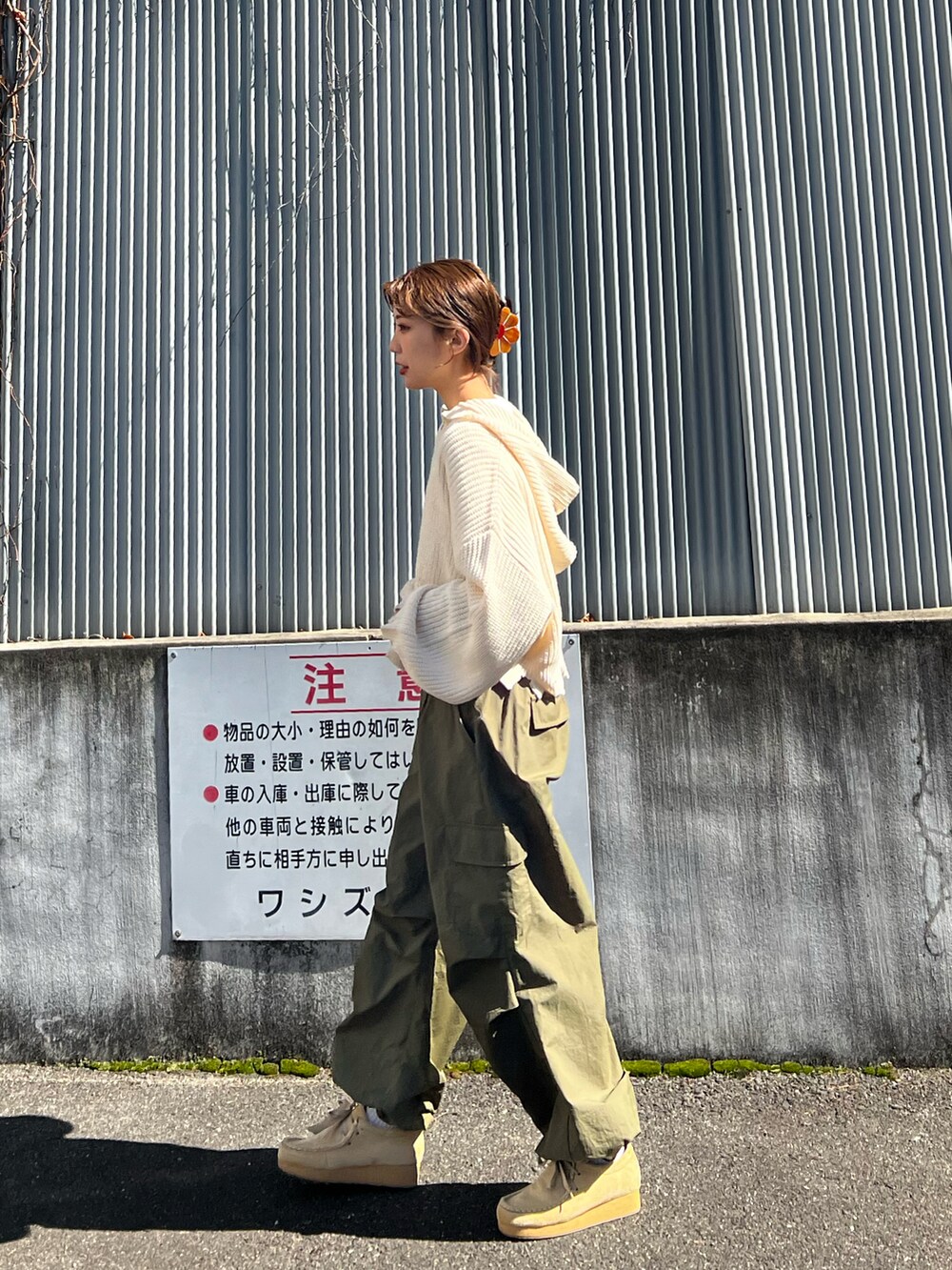 グリーン系のカーゴパンツ、ホワイト系のニット/セーター、ベージュ系のブーツを着用したレディースの春コーディネートの2枚目の写真