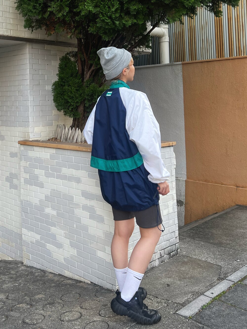 ブルー系のトップス、グレー系のパンツ、ブラック系のスニーカーを着用したレディースの冬コーディネートの2枚目の写真