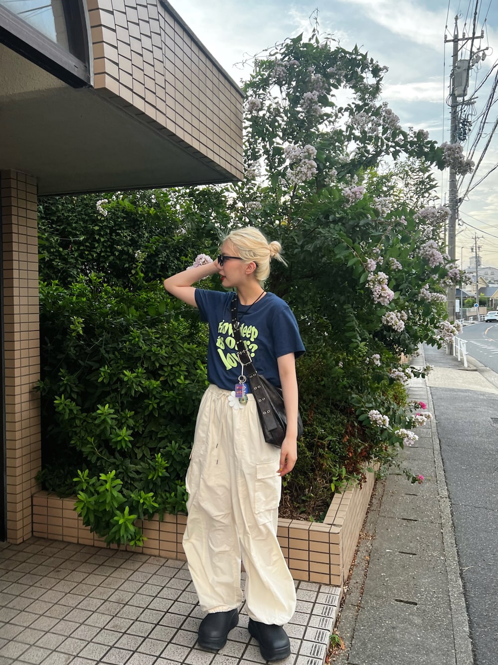 ブルー系のTシャツ/カットソー、ブラウン系のショルダーバッグ、ホワイト系のカーゴパンツを着用したレディースの夏コーディネートの2枚目の写真
