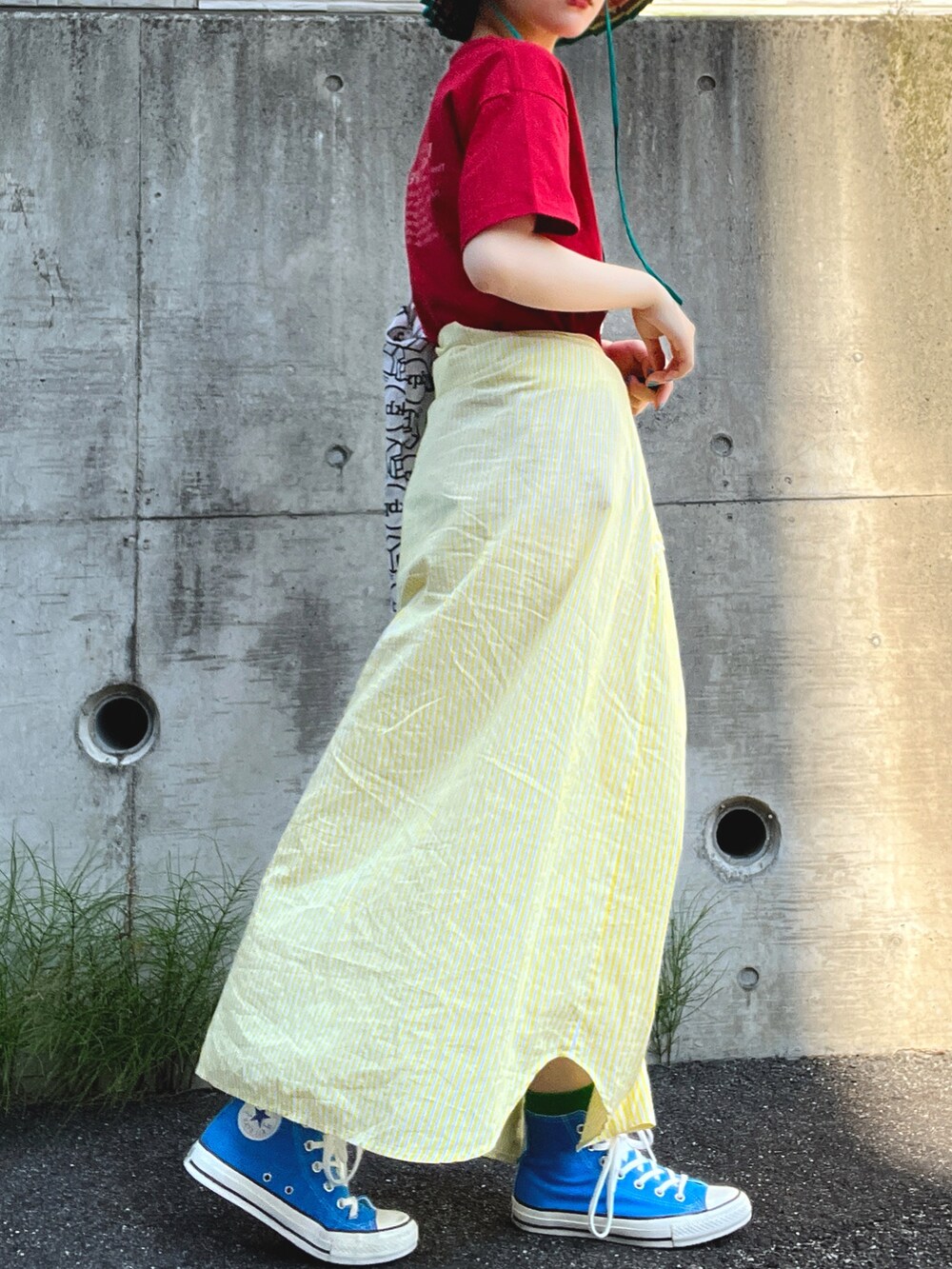 ブルー系のスニーカー、イエロー系のシャツワンピース、レッド系のTシャツ/カットソーを着用したレディースの夏コーディネートの3枚目の写真