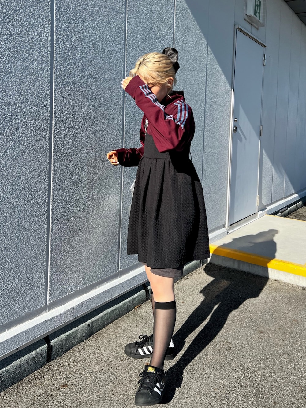 ホワイト系のスニーカー、レッド系のジャージ、シルバー系のショルダーバッグを着用したレディースの秋コーディネートの2枚目の写真