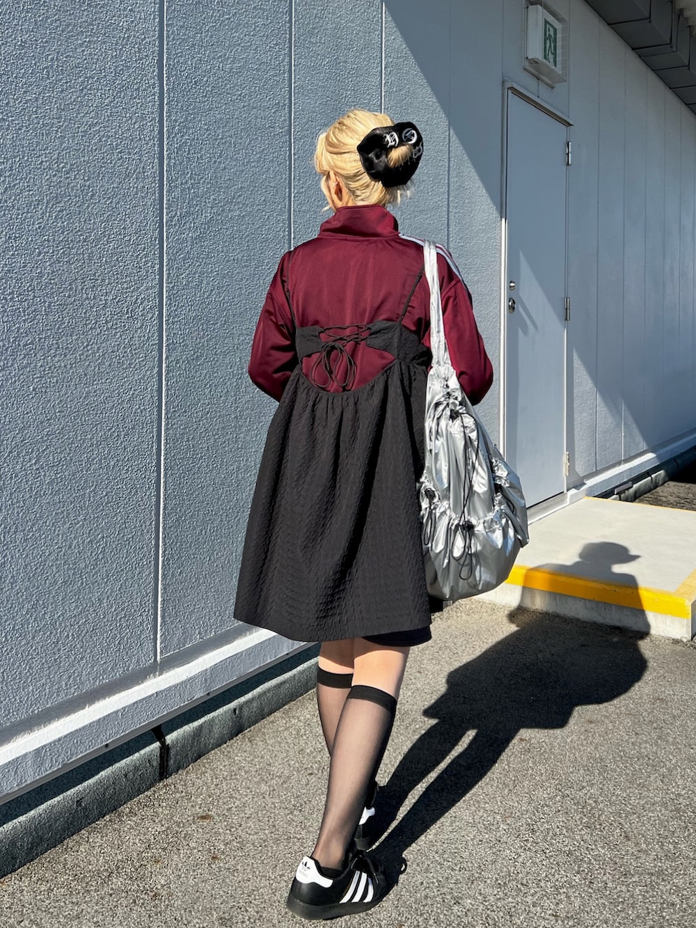 ホワイト系のスニーカー、レッド系のジャージ、シルバー系のショルダーバッグを着用したレディースの秋コーディネートの4枚目の写真