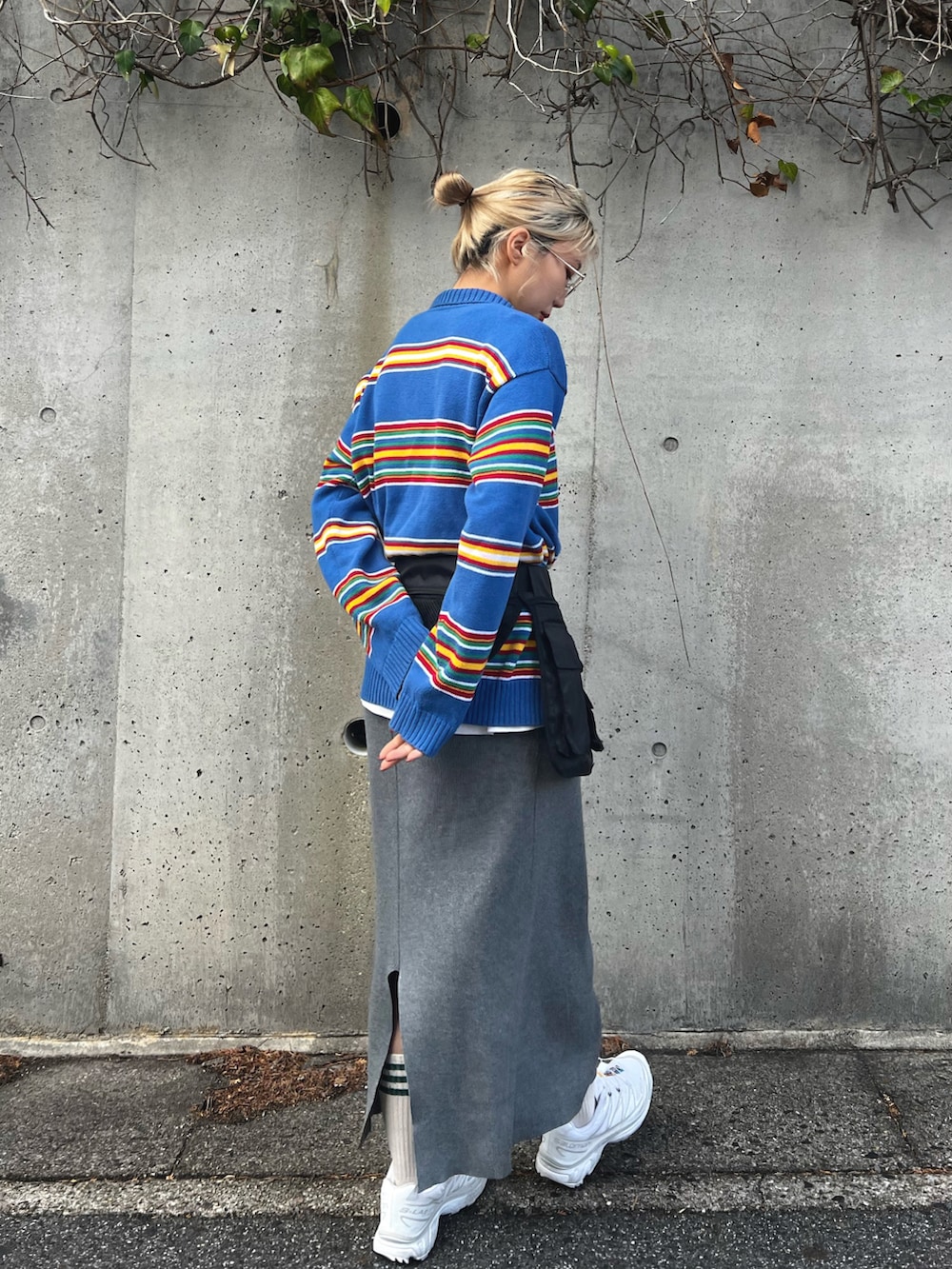 ブルー系のニット/セーター、グレー系のスカート、ブラック系のボディバッグ/ウエストポーチを着用したレディースの冬コーディネートの2枚目の写真