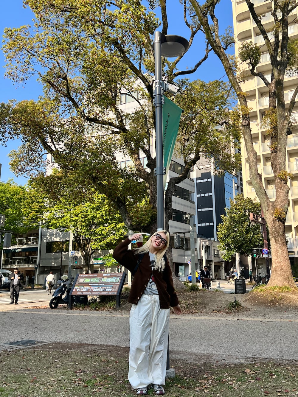 ピンク系のスニーカー、ホワイト系のパンツ、レッド系のバックパック/リュックを着用したレディースの春コーディネートの2枚目の写真