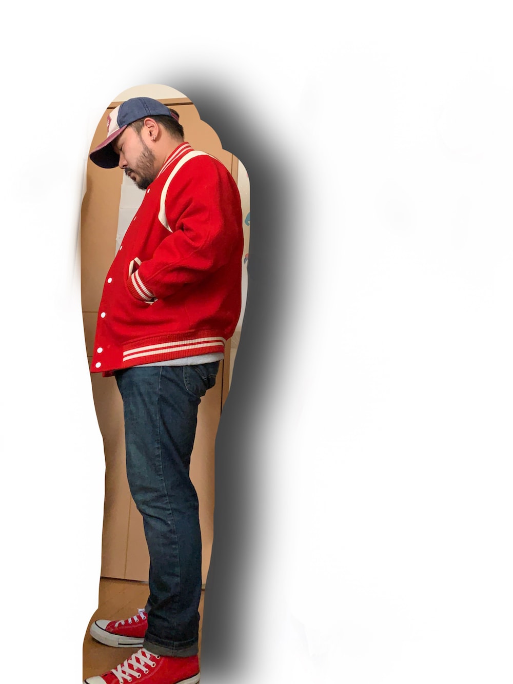 グレー系のスウェット、レッド系のスタジャン、ブルー系のデニムパンツを着用したメンズの春コーディネートの2枚目の写真