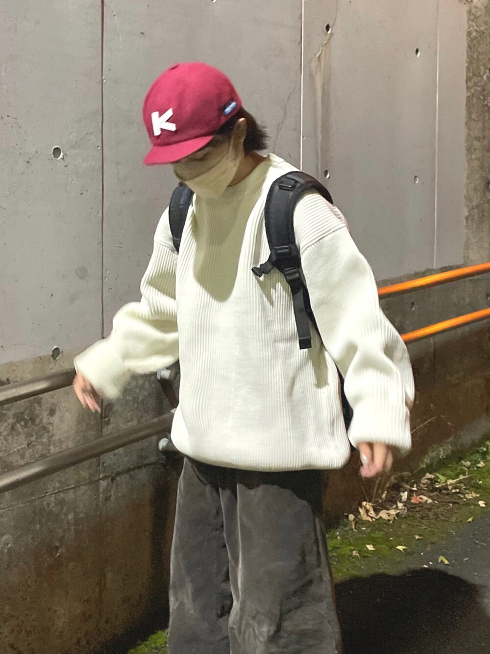 ブラック系のバックパック/リュック、ホワイト系のニット/セーター、ブラック系のパンツを着用したレディースの冬コーディネートの2枚目の写真