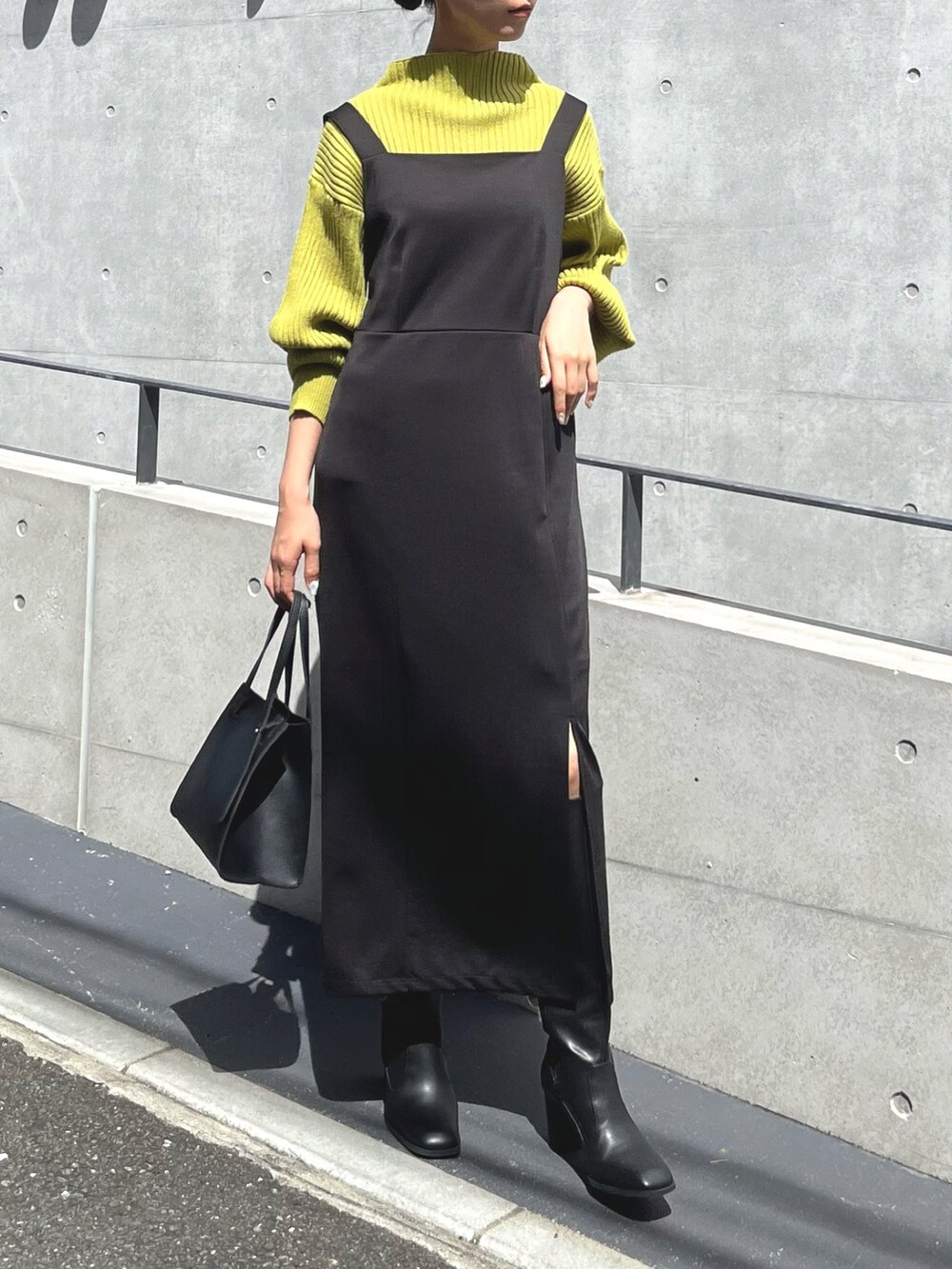 ブラック系のワンピース/ドレス、イエロー系のニット/セーター、ブラック系のバッグを着用したレディースの夏コーディネートの2枚目の写真