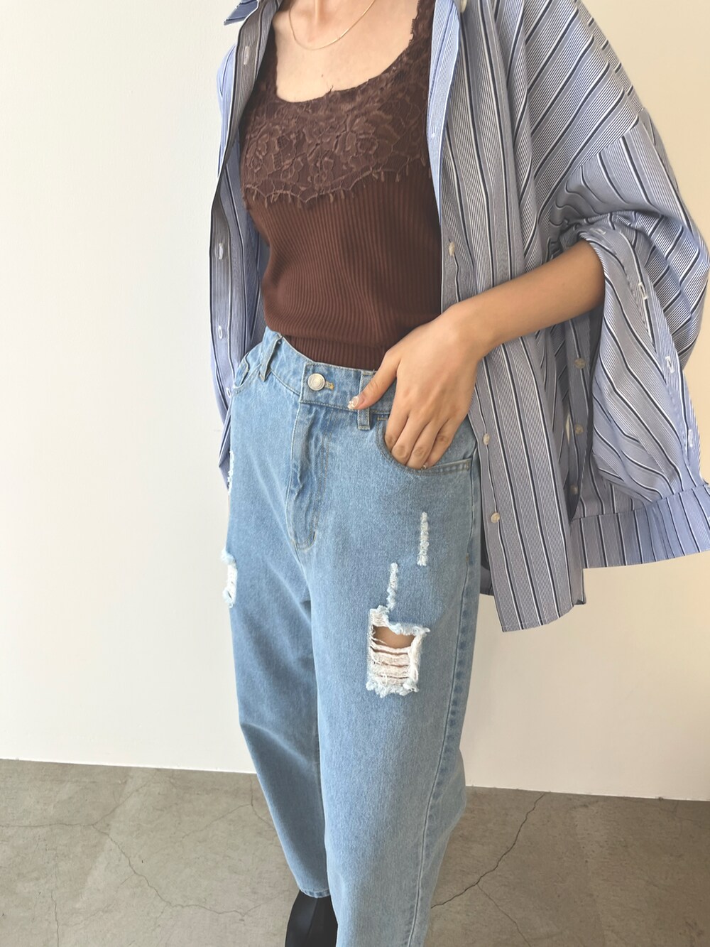 ブラウン系のキャミソール、ブルー系のシャツ/ブラウス、ブルー系のデニムパンツを着用したレディースの夏コーディネートの2枚目の写真