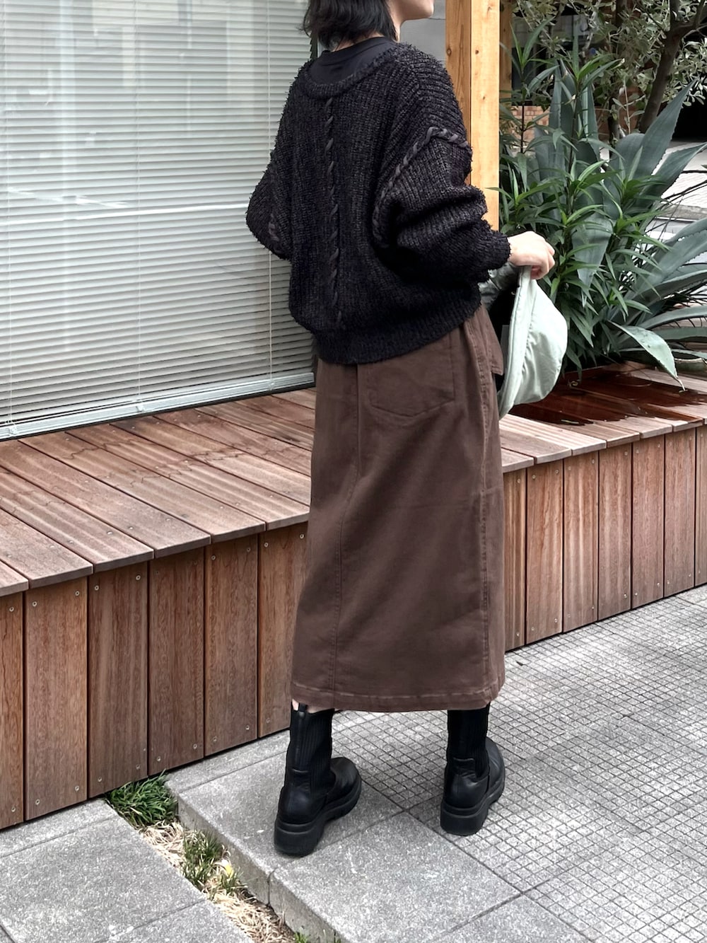 ブラック系のTシャツ/カットソー、ブラック系のニット/セーター、グリーン系のブーツを着用したレディースの秋コーディネートの4枚目の写真