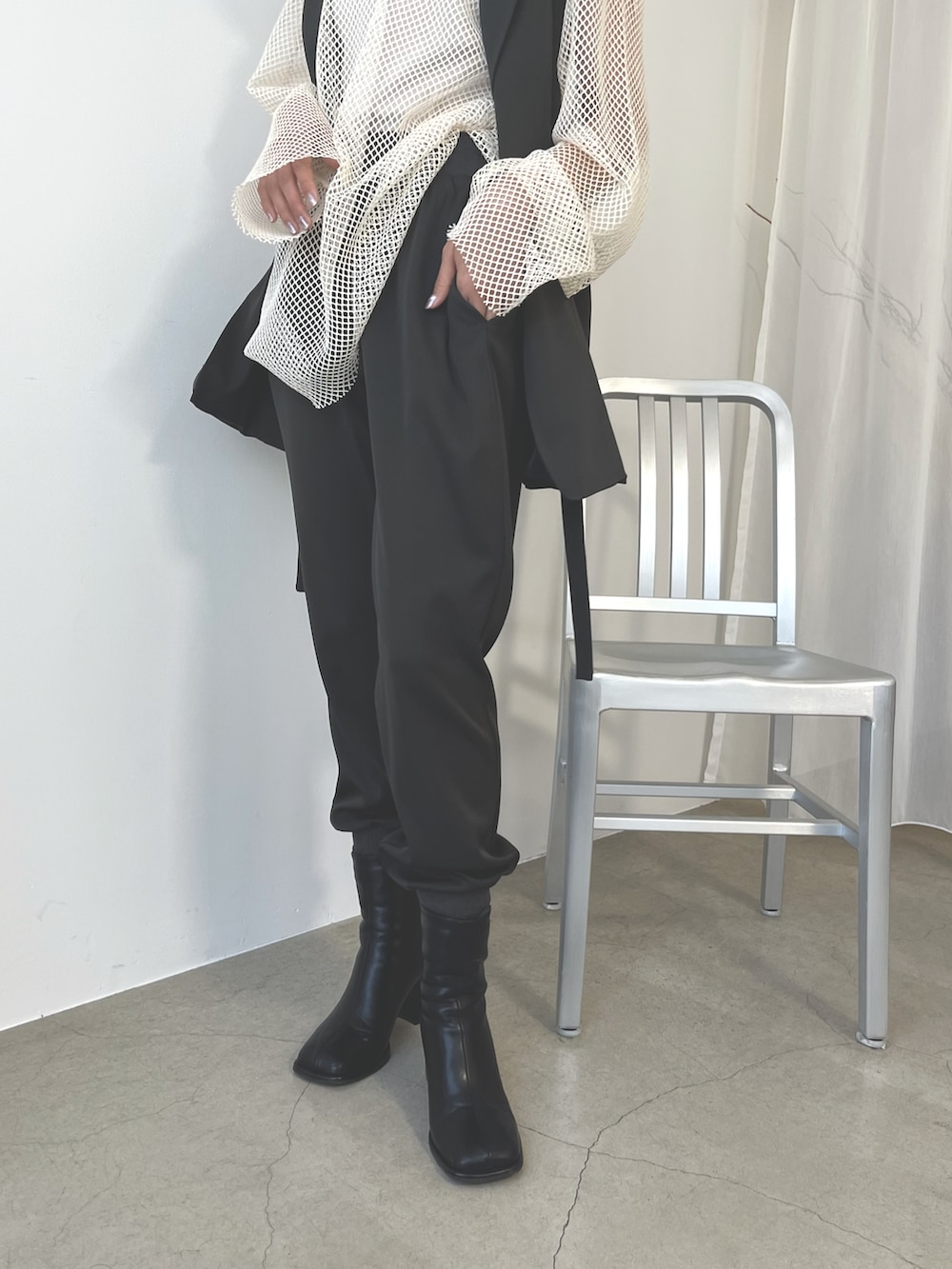 グレー系のスウェットパンツ、ブラック系のブーツ、ホワイト系のニット/セーターを着用したレディースの秋コーディネートの5枚目の写真