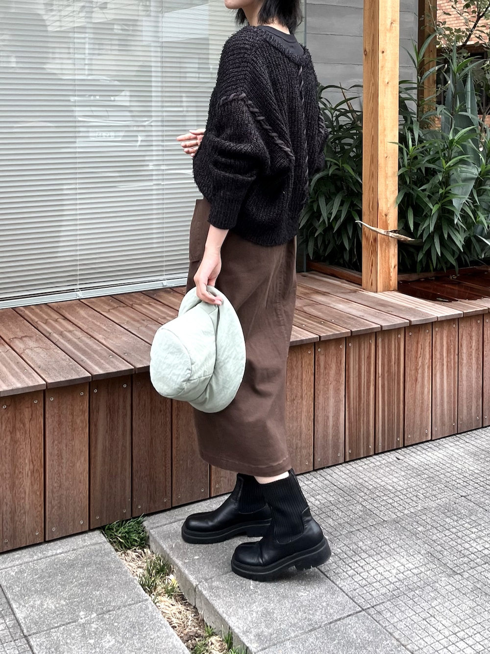 ブラック系のTシャツ/カットソー、ブラック系のニット/セーター、グリーン系のブーツを着用したレディースの秋コーディネートの3枚目の写真