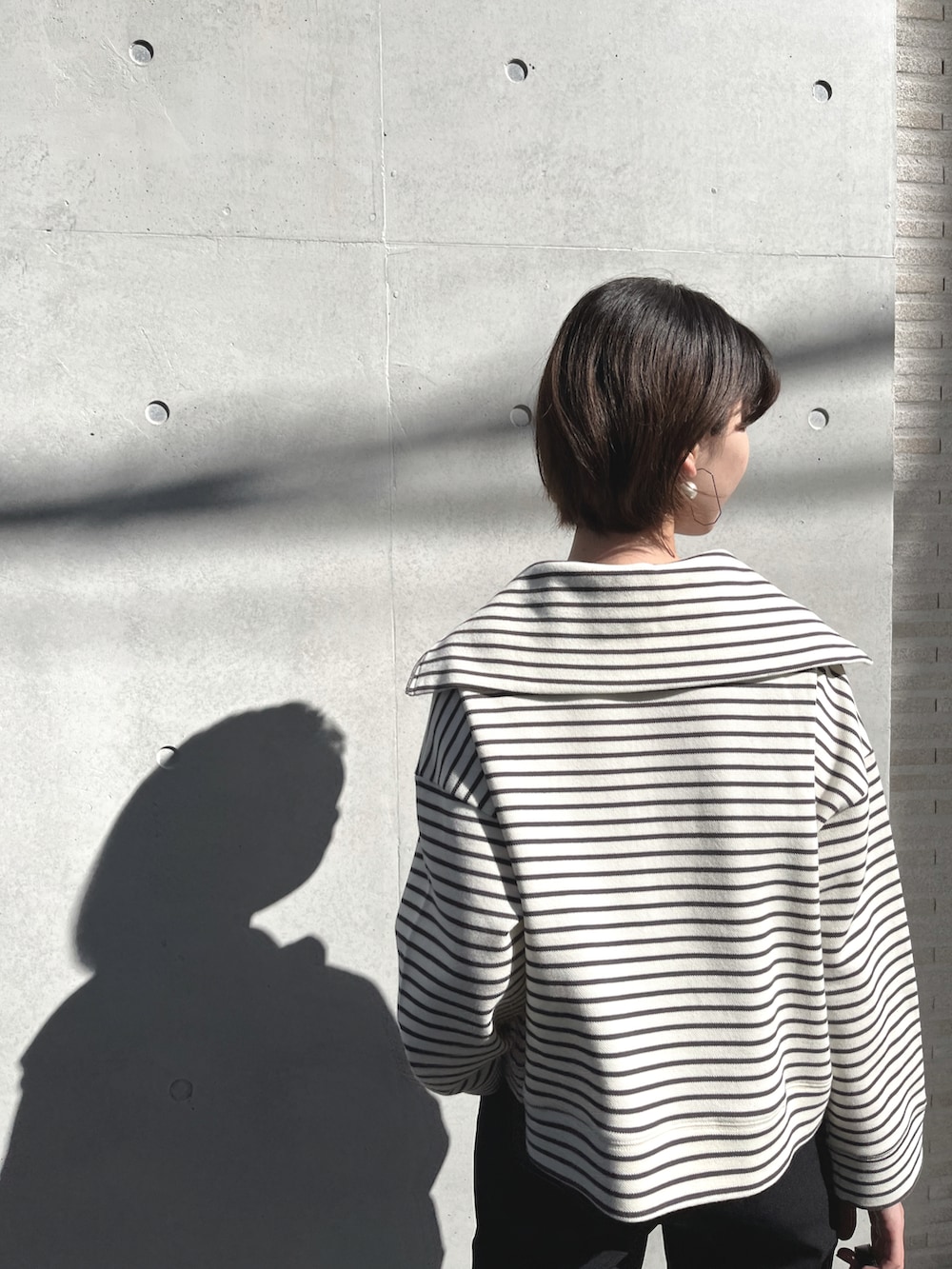 ブラック系のブーツ、ホワイト系のTシャツ/カットソー、ブラック系のスウェットパンツを着用したレディースの冬コーディネートの3枚目の写真