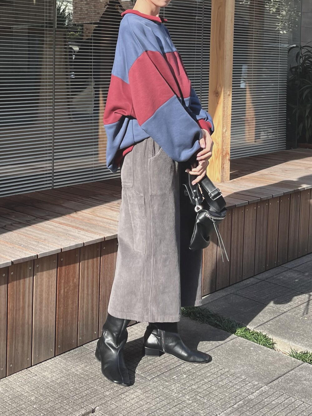 レッド系のトップスを着用したレディースの秋コーディネートの3枚目の写真