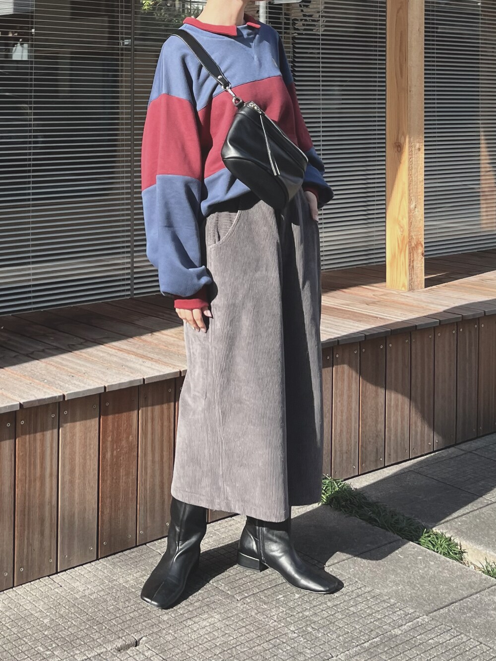 レッド系のトップスを着用したレディースの秋コーディネートの4枚目の写真