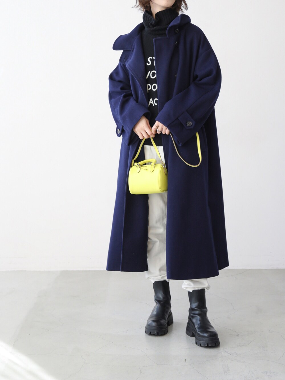 グリーン系のその他アウター、イエロー系の手袋を着用したレディースの冬コーディネートの2枚目の写真