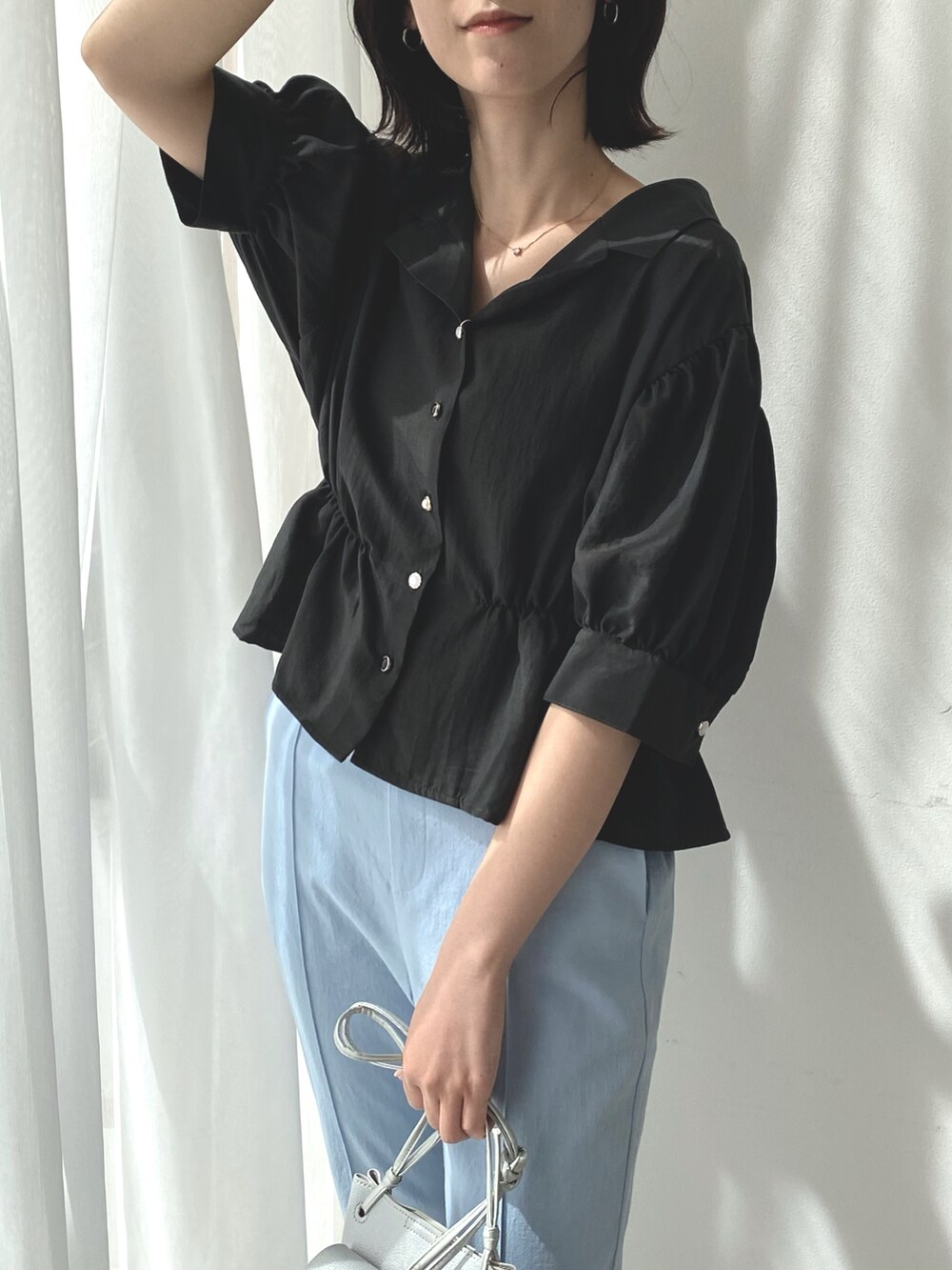 ブラック系のシャツ/ブラウス、ブルー系のスラックス、その他のバッグを着用したレディースの春コーディネートの2枚目の写真