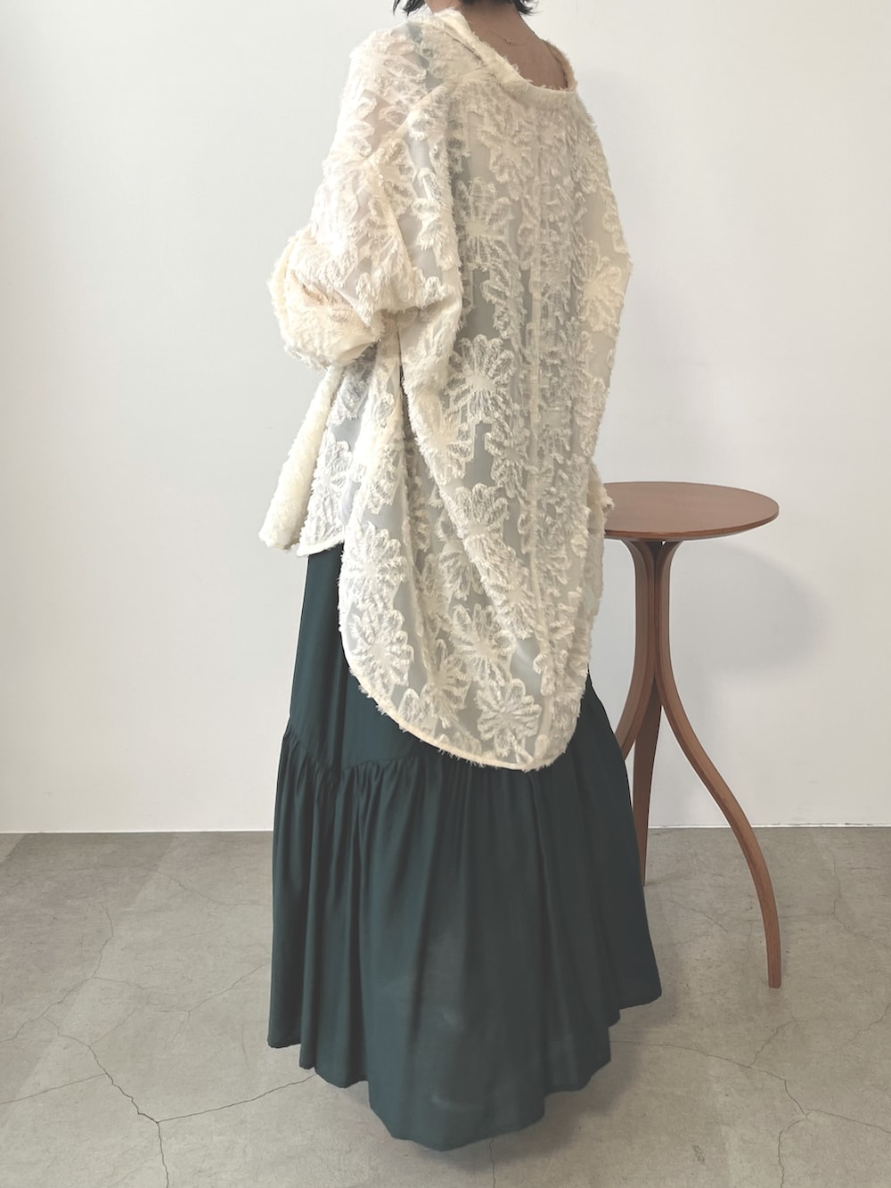 シルバー系のバレエシューズ、グリーン系のジャンパースカート、ホワイト系のシャツ/ブラウスを着用したレディースの秋コーディネートの2枚目の写真