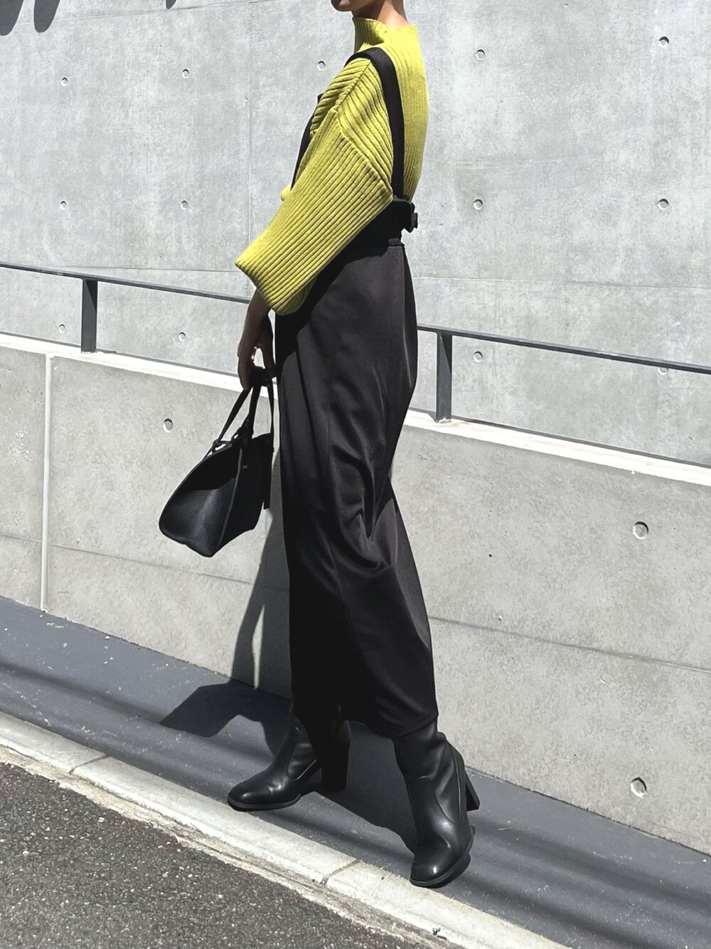 ブラック系のワンピース/ドレス、イエロー系のニット/セーター、ブラック系のバッグを着用したレディースの夏コーディネートの3枚目の写真