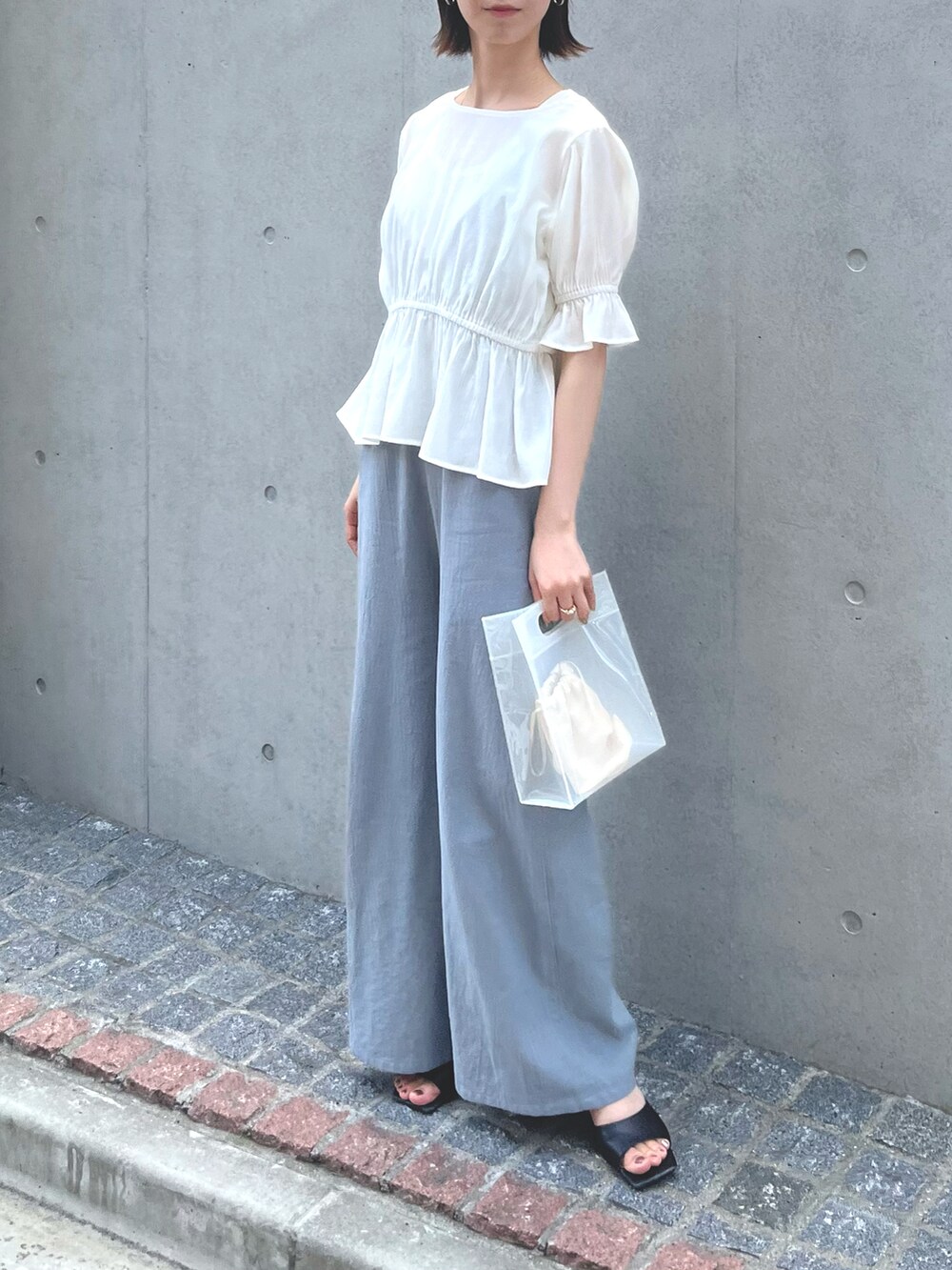 ブルー系のつなぎ/オールインワン、ブラック系のサンダル、ホワイト系のバッグを着用したレディースの春コーディネートの3枚目の写真