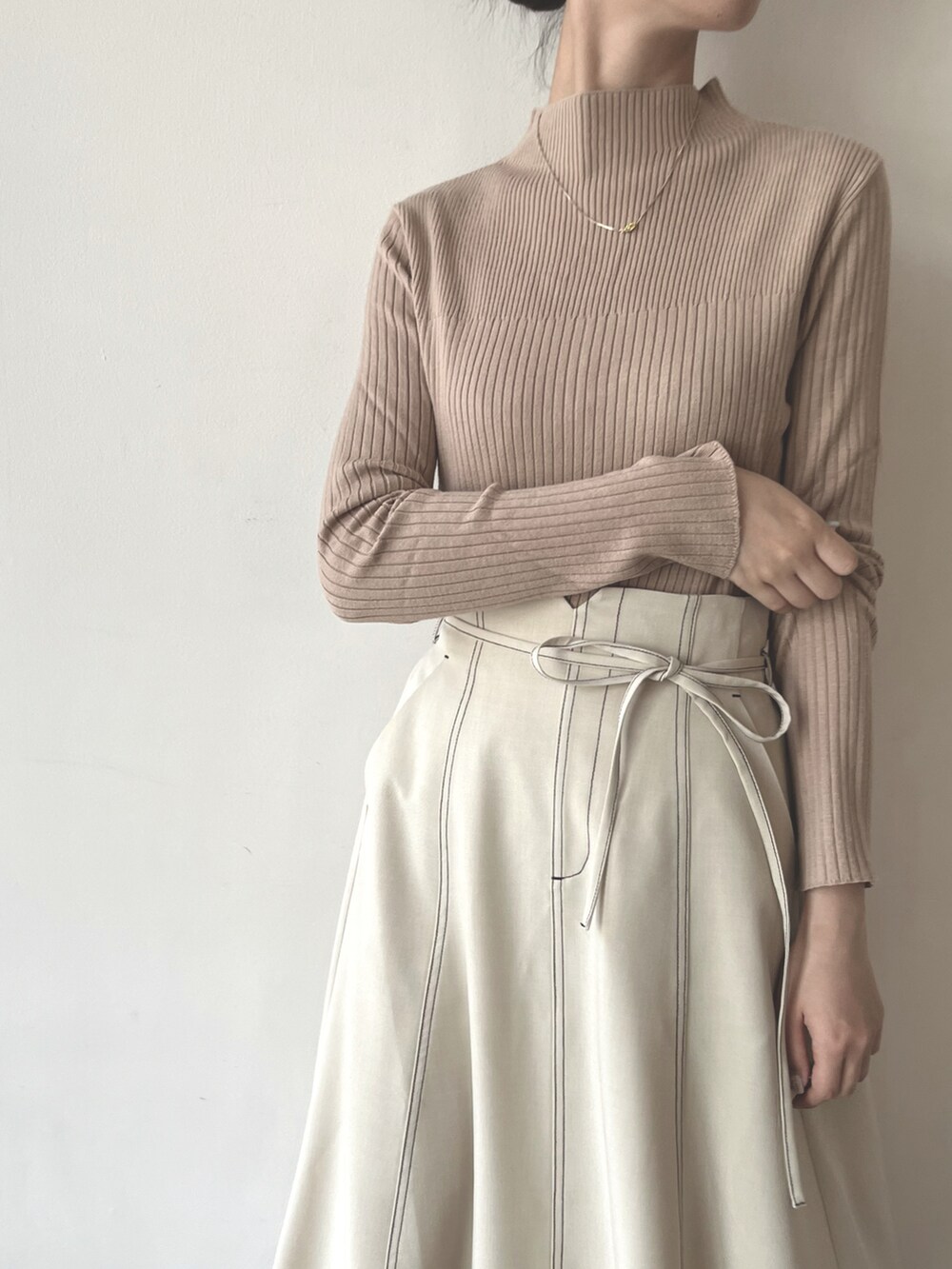 ホワイト系のスカート、その他のシューズ、ベージュ系のニット/セーターを着用したレディースの夏コーディネートの2枚目の写真