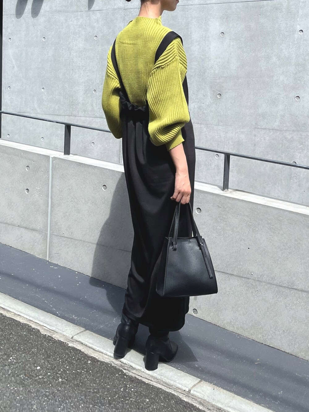 ブラック系のワンピース/ドレス、イエロー系のニット/セーター、ブラック系のバッグを着用したレディースの夏コーディネートの4枚目の写真