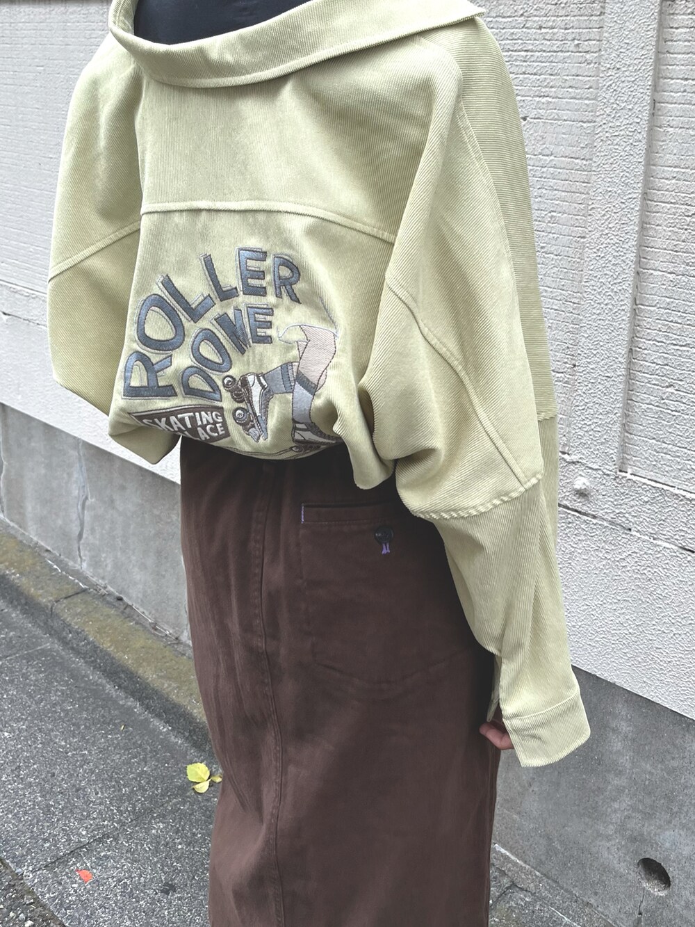 ブラック系のTシャツ/カットソー、イエロー系のシャツワンピース、ブラウン系のスカートを着用したレディースの秋コーディネートの5枚目の写真