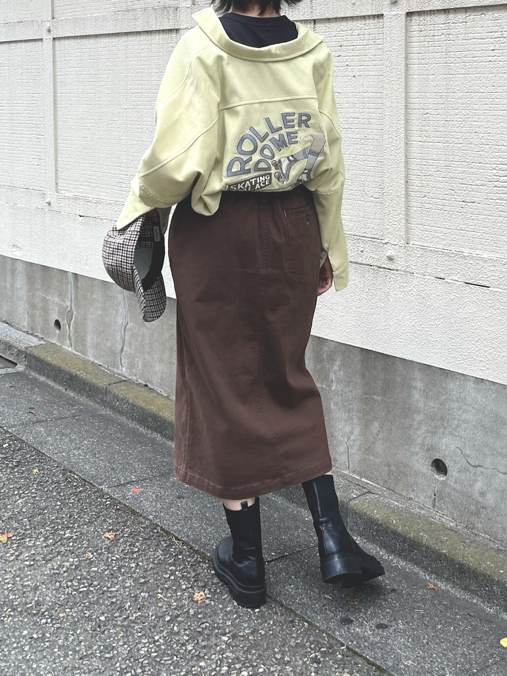 ブラック系のTシャツ/カットソー、イエロー系のシャツワンピース、ブラウン系のスカートを着用したレディースの秋コーディネートの4枚目の写真