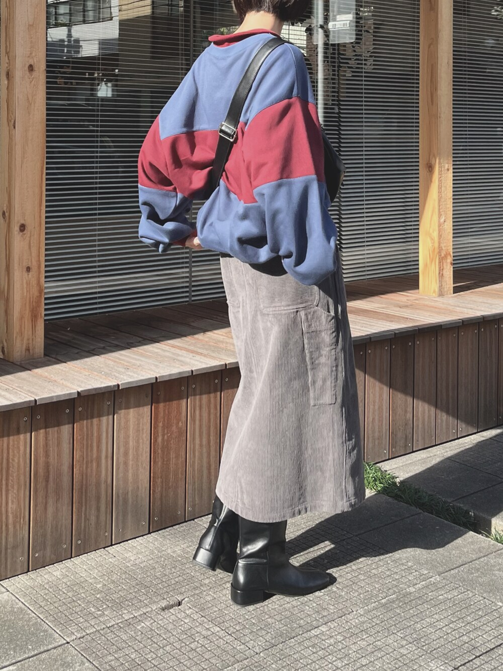 レッド系のトップスを着用したレディースの秋コーディネートの2枚目の写真