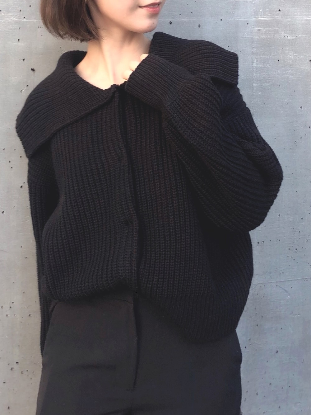 ブラック系のカーディガン/ボレロ、ブラック系のスラックス、ブラック系のブーツを着用したレディースの冬コーディネートの2枚目の写真