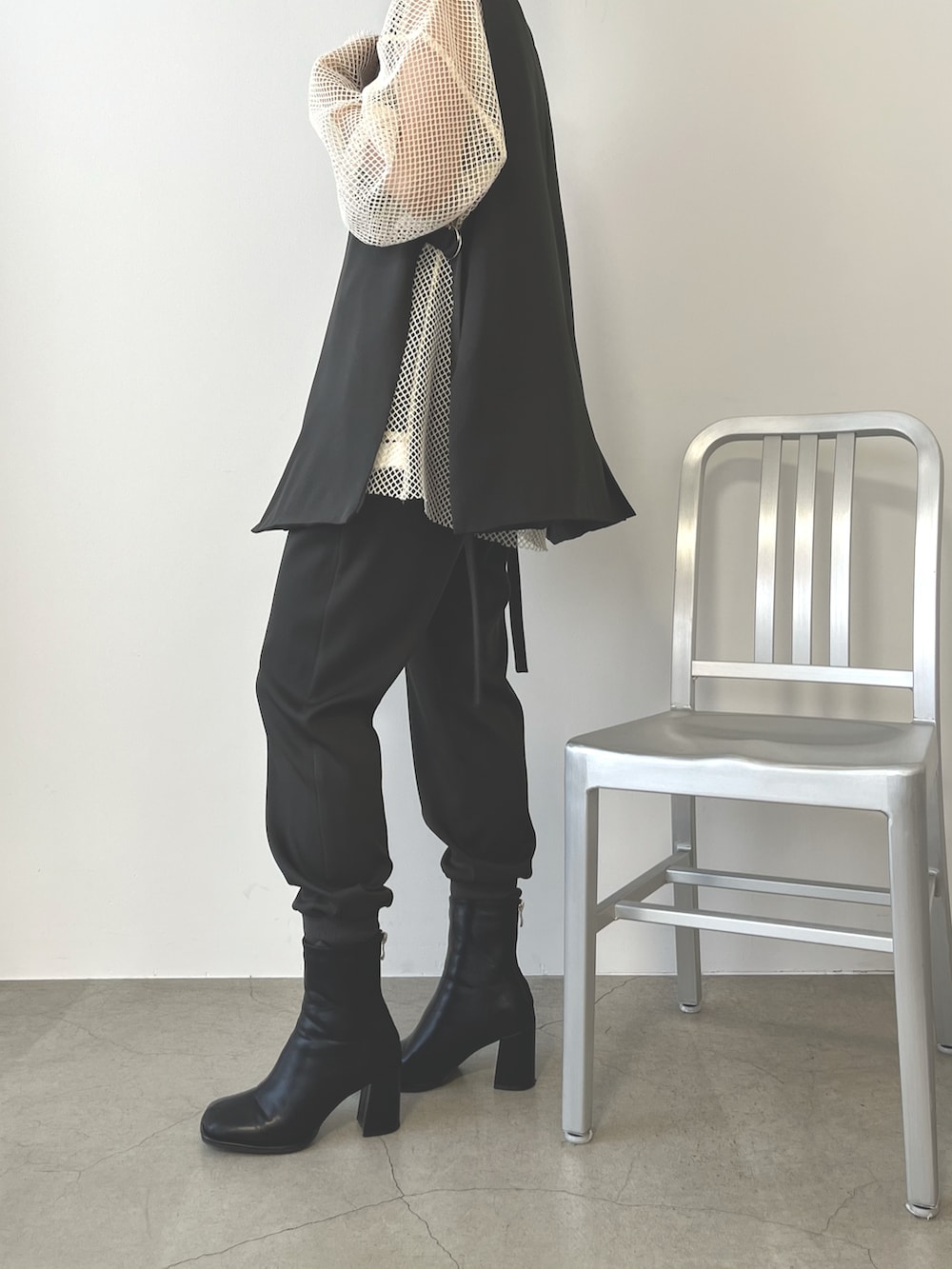 グレー系のスウェットパンツ、ブラック系のブーツ、ホワイト系のニット/セーターを着用したレディースの秋コーディネートの4枚目の写真