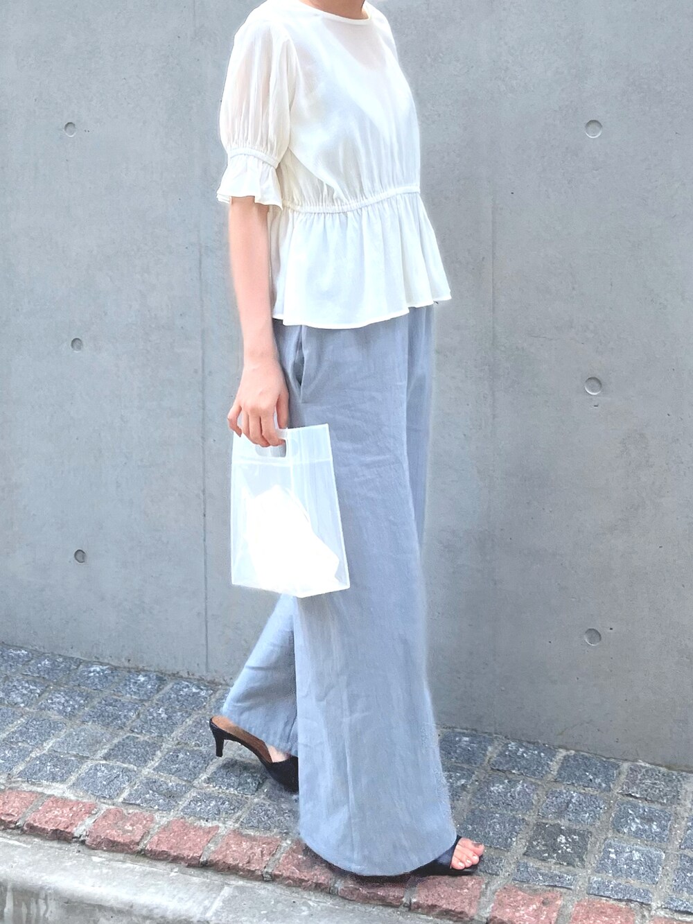 ブルー系のつなぎ/オールインワン、ブラック系のサンダル、ホワイト系のバッグを着用したレディースの春コーディネートの4枚目の写真